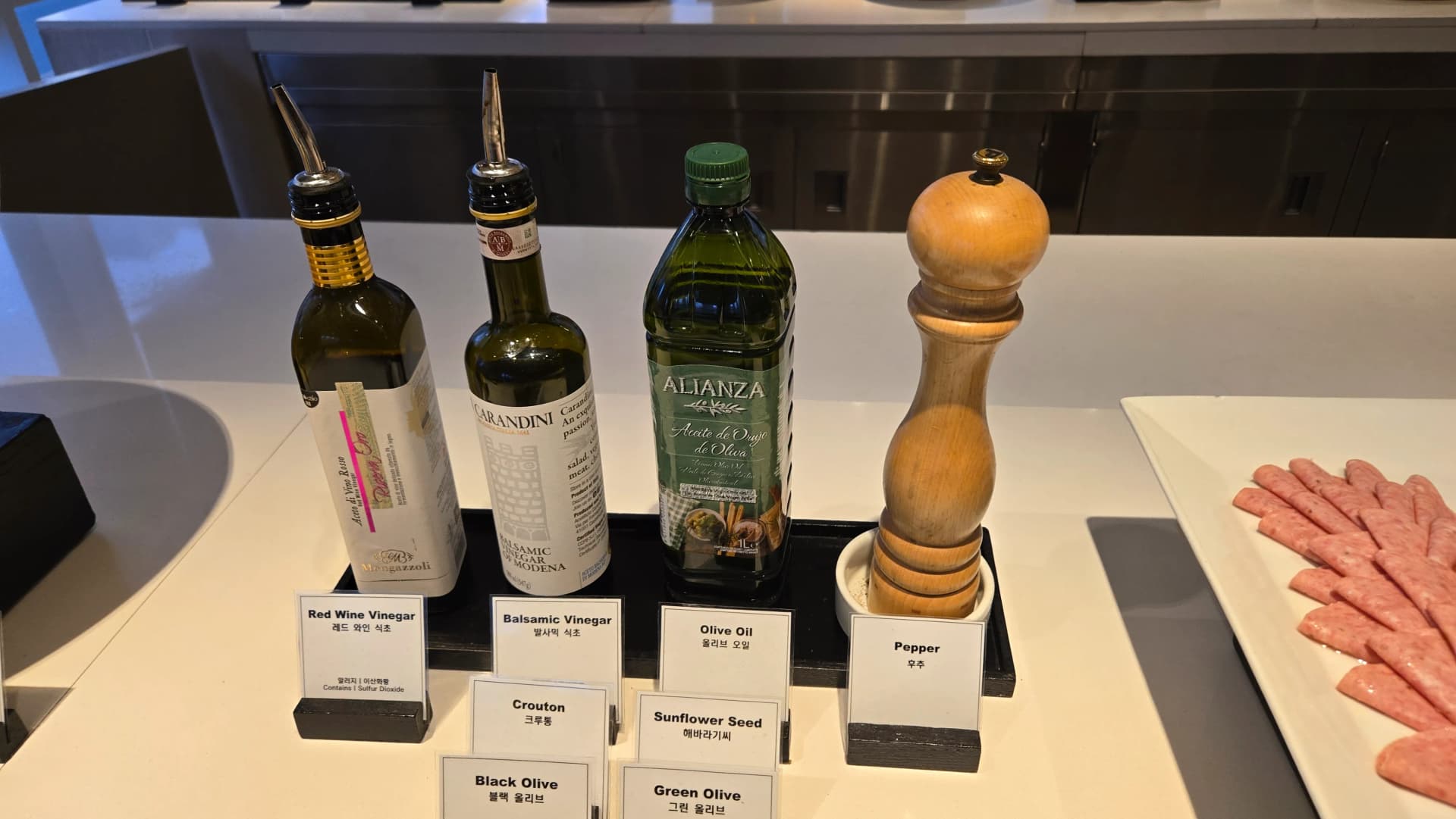 ركن تتبيلات السلطة في بوفيه الفطور مع خل وزيت وزيتون وقطع خبز محمصة