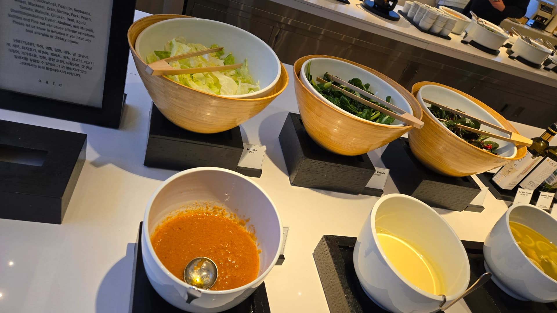 ركن سلطات خضار في بوفيه الفطور داخل أوعية خشبية مع تتبيلتين مختلفتين