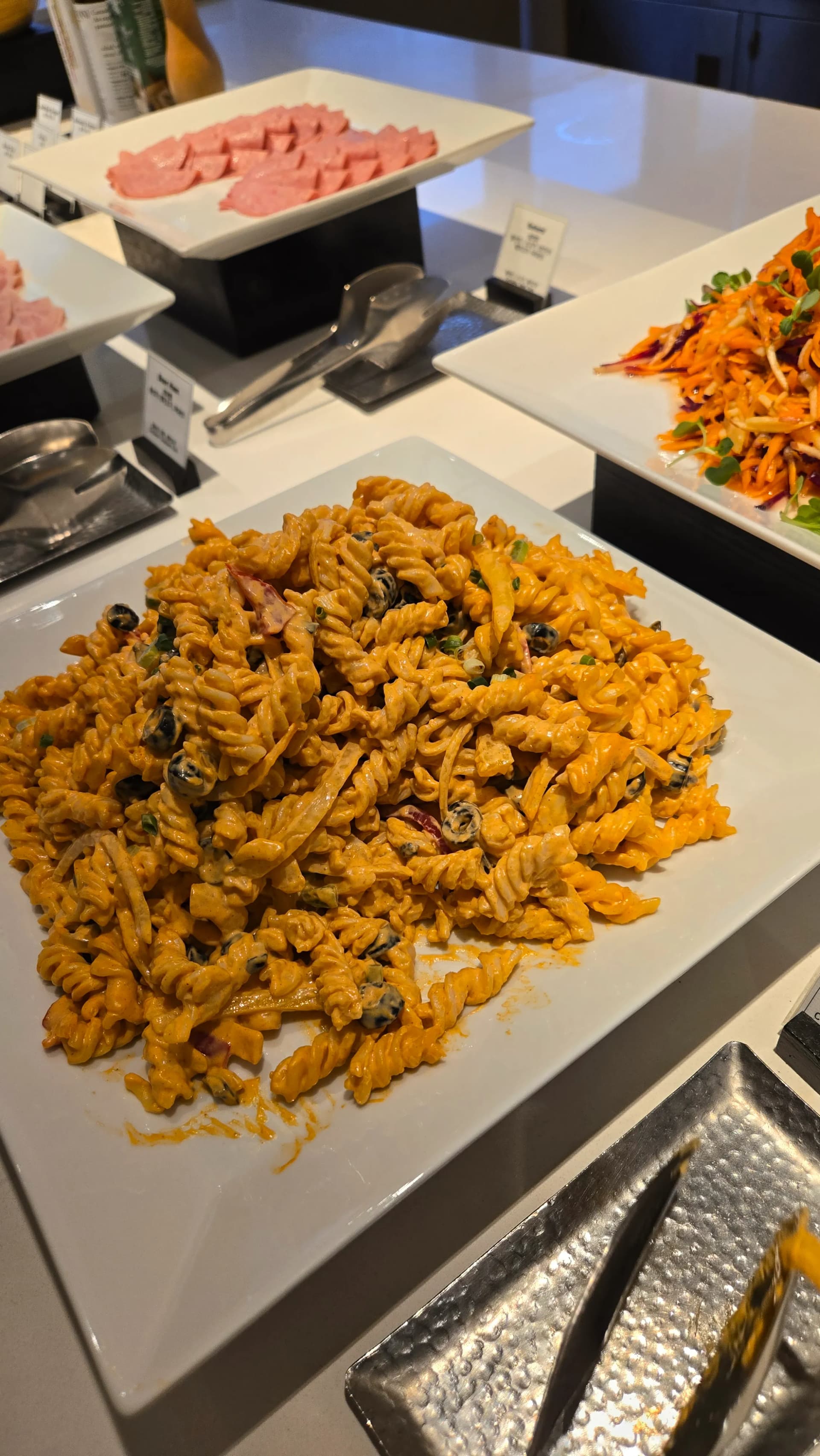 سلطة باستا فوسيلي باردة في بوفيه الفطور مع صلصة غنية وزيتون ولحم