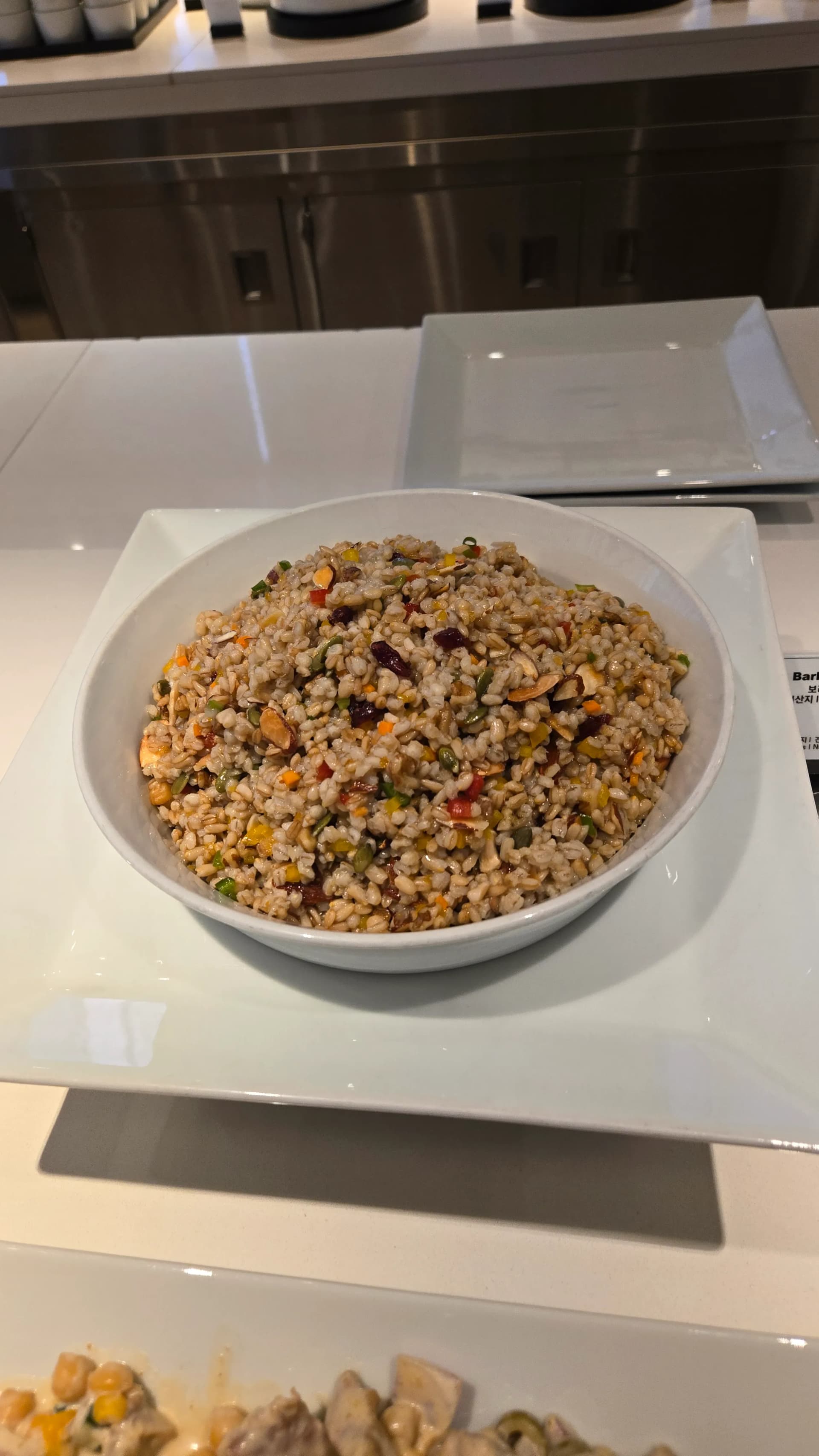 سلطة شعير صحية في بوفيه الفطور مع كرانبيري ولوز وفلفل ملون