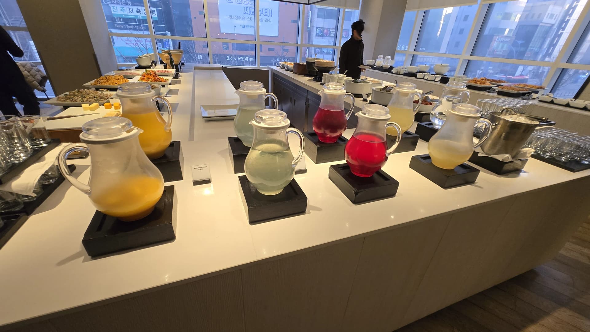 ركن مشروبات بوفيه الفطور مع أباريق زجاجية بألوان عصائر مختلفة