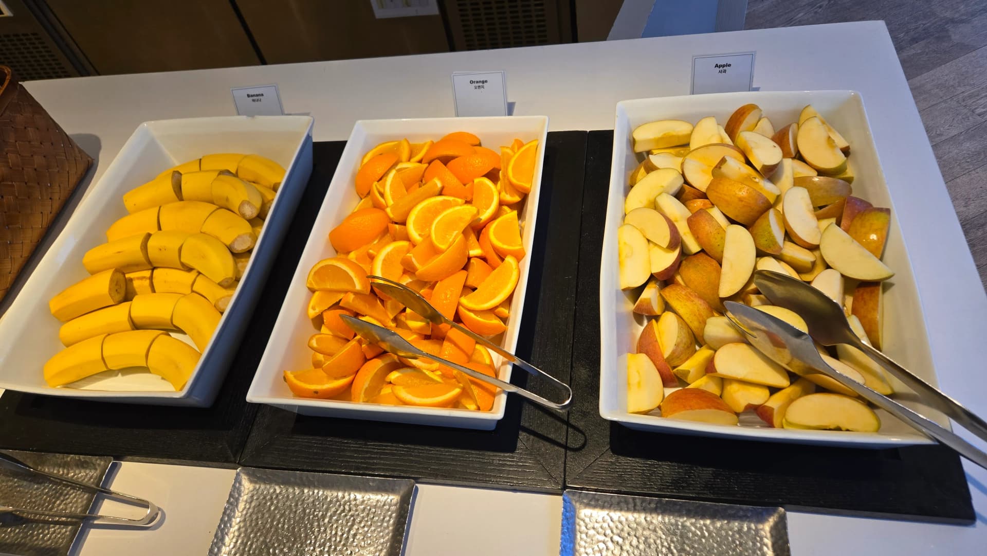 ركن فاكهة في بوفيه الفطور يضم موزاً وبرتقالاً وتفاحاً مقطعاً