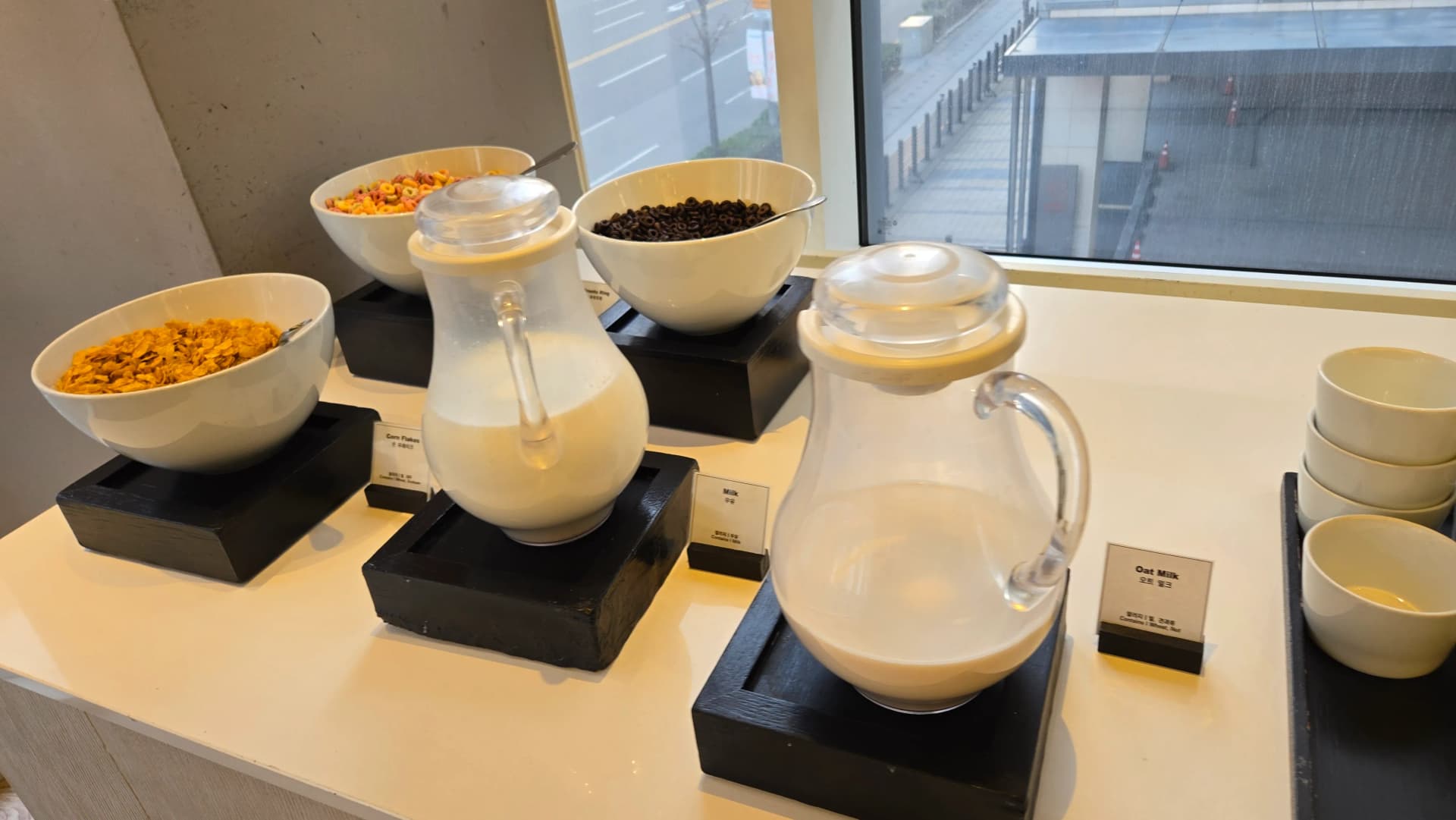 ركن حبوب إفطار في بوفيه الفطور مع رقائق ذرة وحلقات فواكه وكرات شوكولاتة وحليب