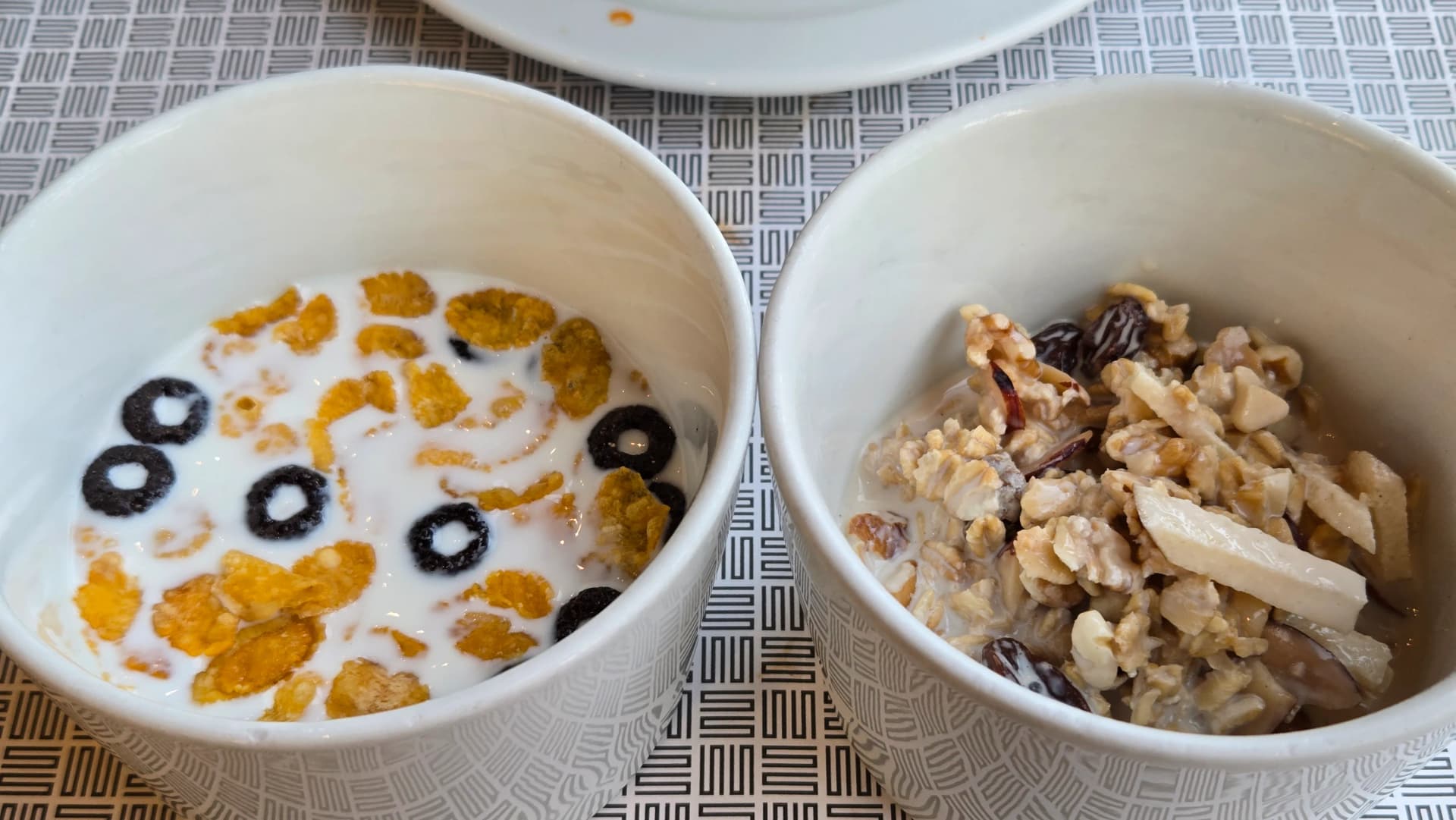 وعاءان من الحبوب في نهاية بوفيه الفطور مع رقائق ذرة وشوكولاتة وميوسلي بالحليب