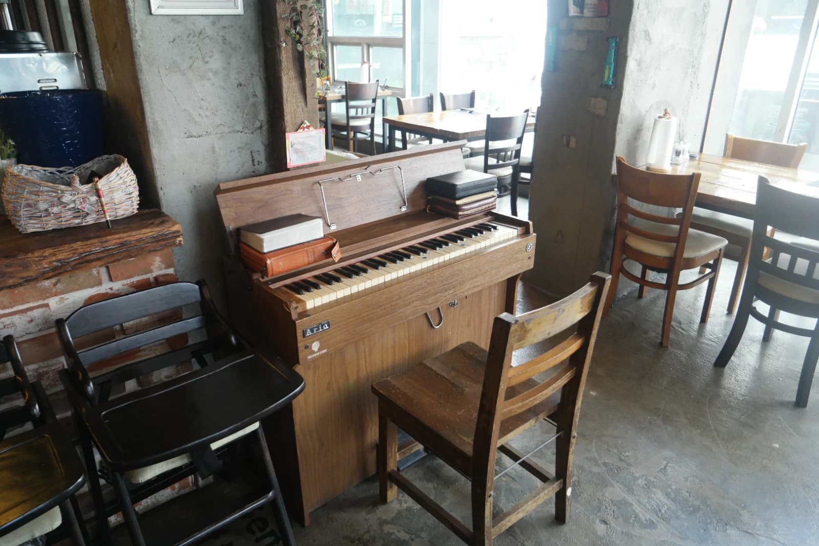韓国・大田のステーキ専門店の店内、コンクリート壁の前に古いピアノが置かれ鍵盤の上にメニューが積まれている様子