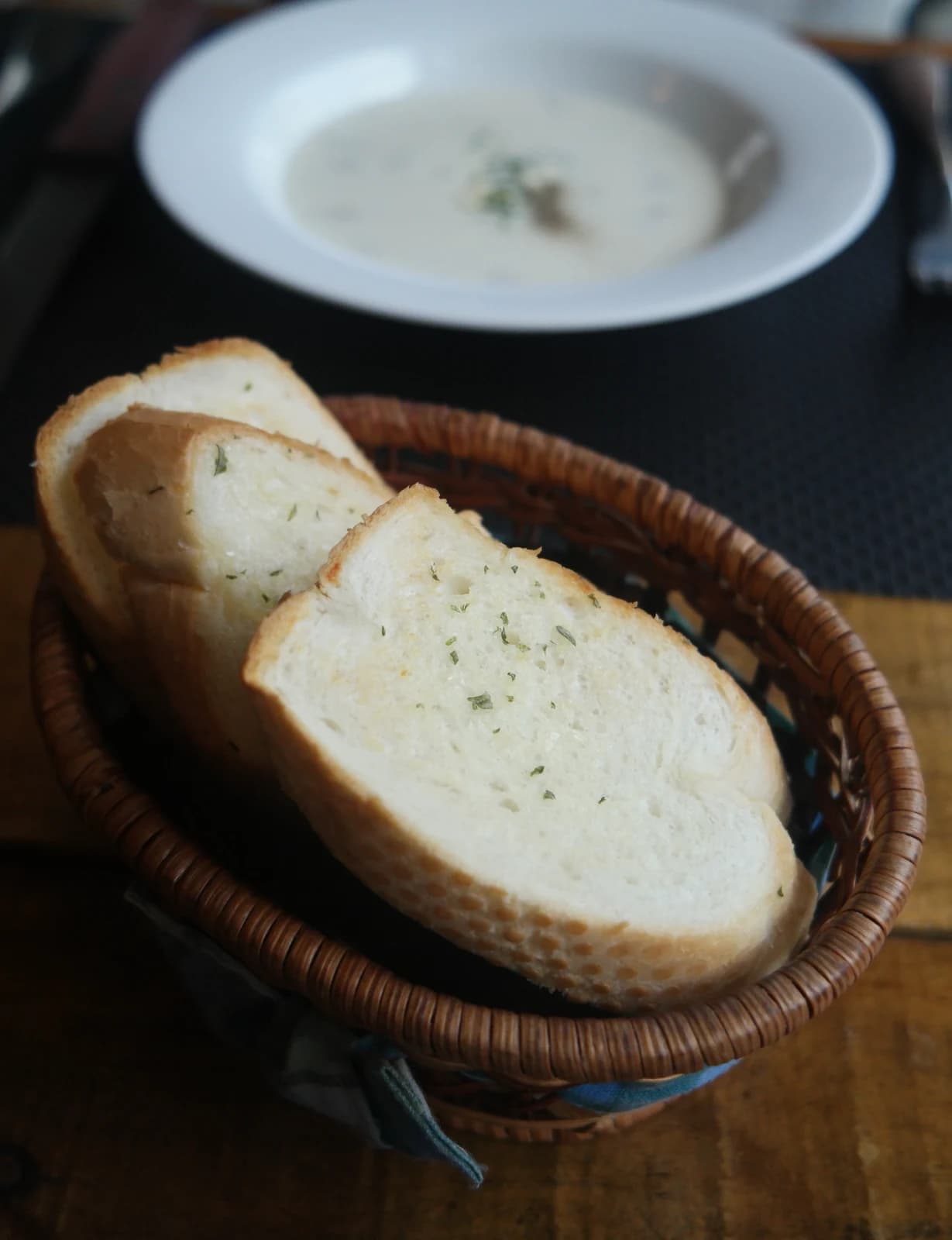 ラタンかごに入ったバゲット2切れにパセリが振られている様子