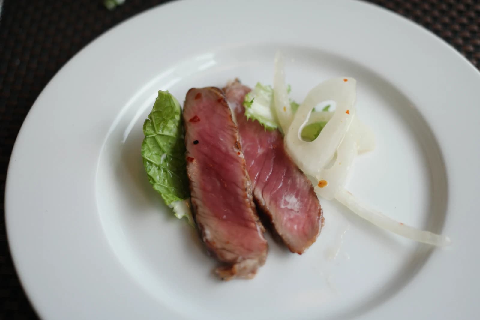 皿に取り分けたサーロインステーキサラダ、肉2切れと野菜