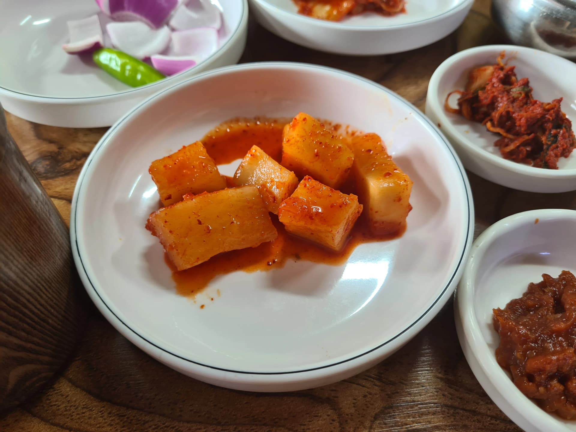 كاكدوقي مكعبات فجل مخلل بلون فاتح وشفاف على صحن أبيض — طازج وخفيف التخمير يؤكل مع شوربة عظم الخنزير