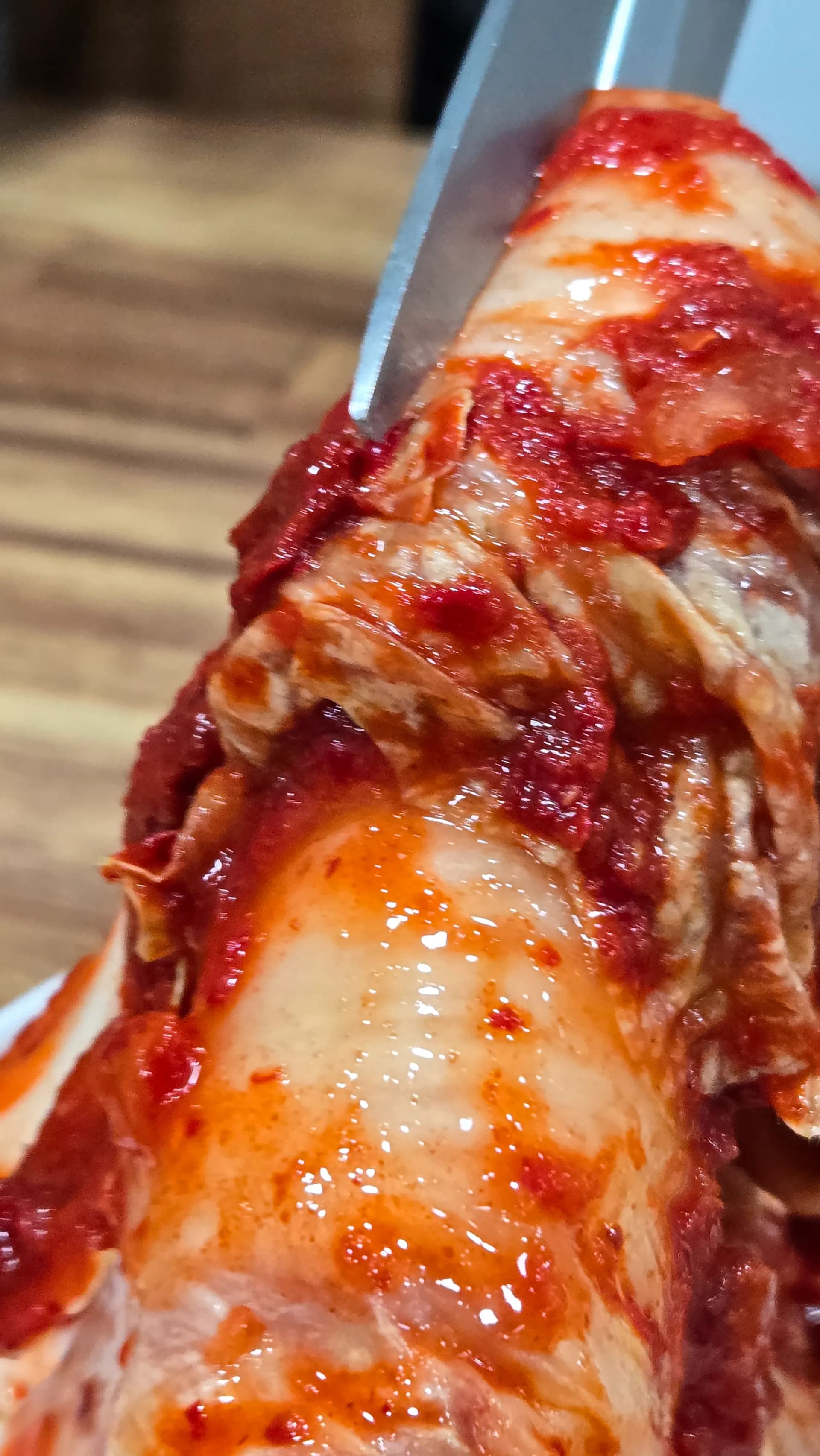 Cutting kimchi into bite-sized pieces with kitchen scissors at a Korean restaurant table