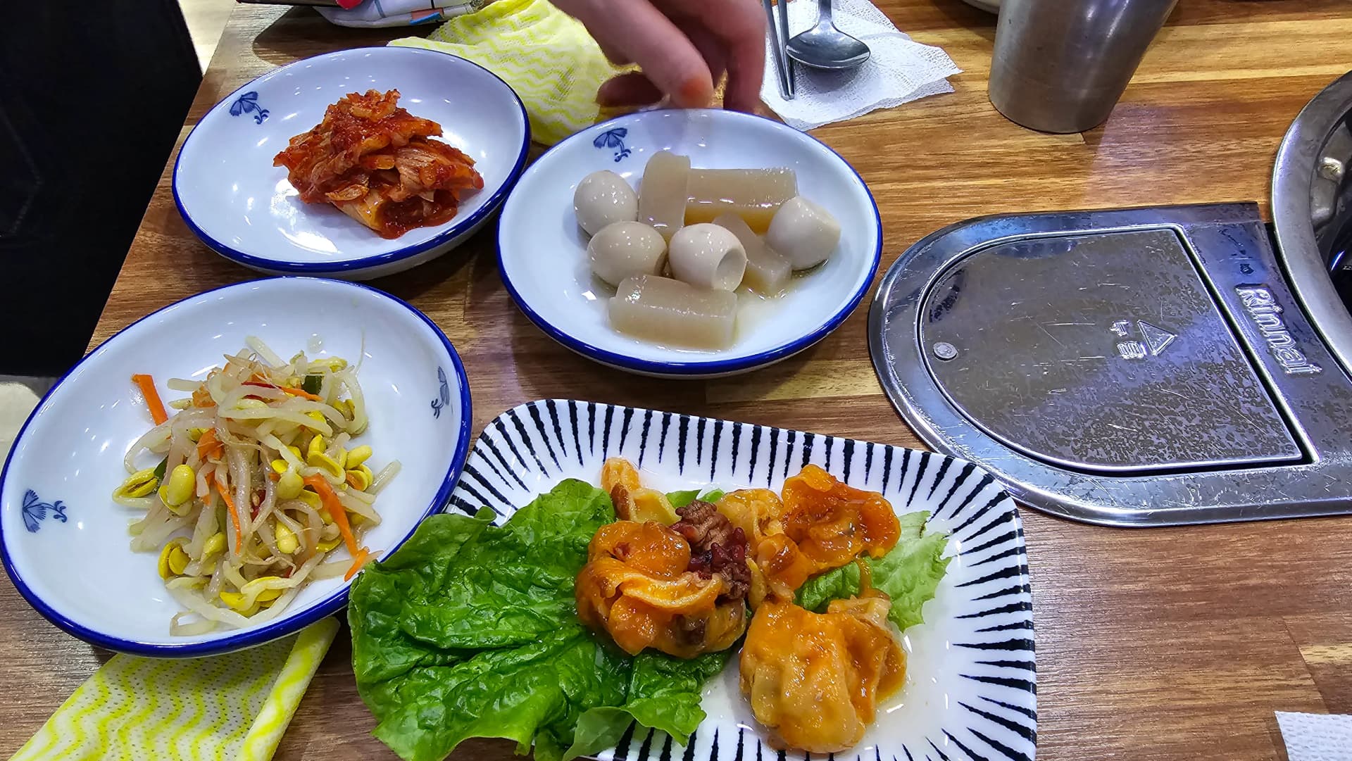 Interior del restaurante de mariscos al vapor en Tongyeong, sentados a la mesa esperando el pedido