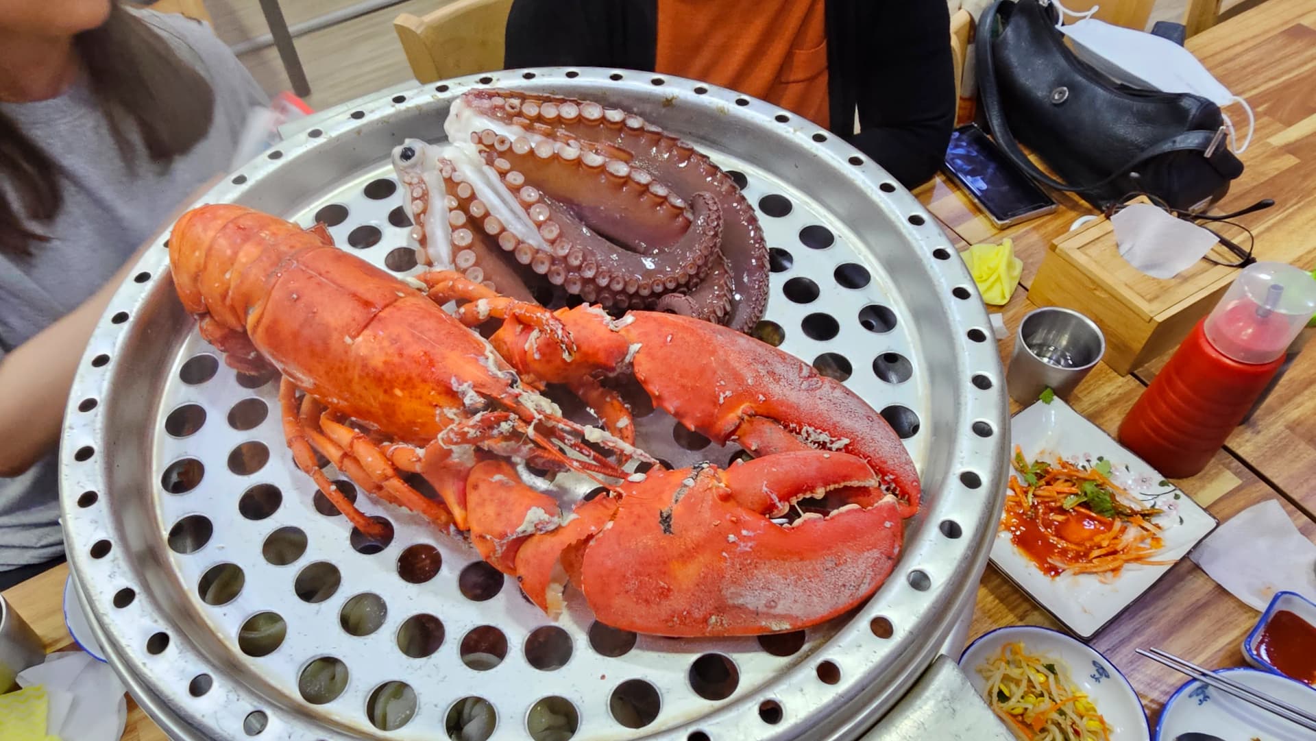 Torre de jogaejjim de 5 pisos apilada sobre la mesa con salsas de vinagre picante y soya al costado