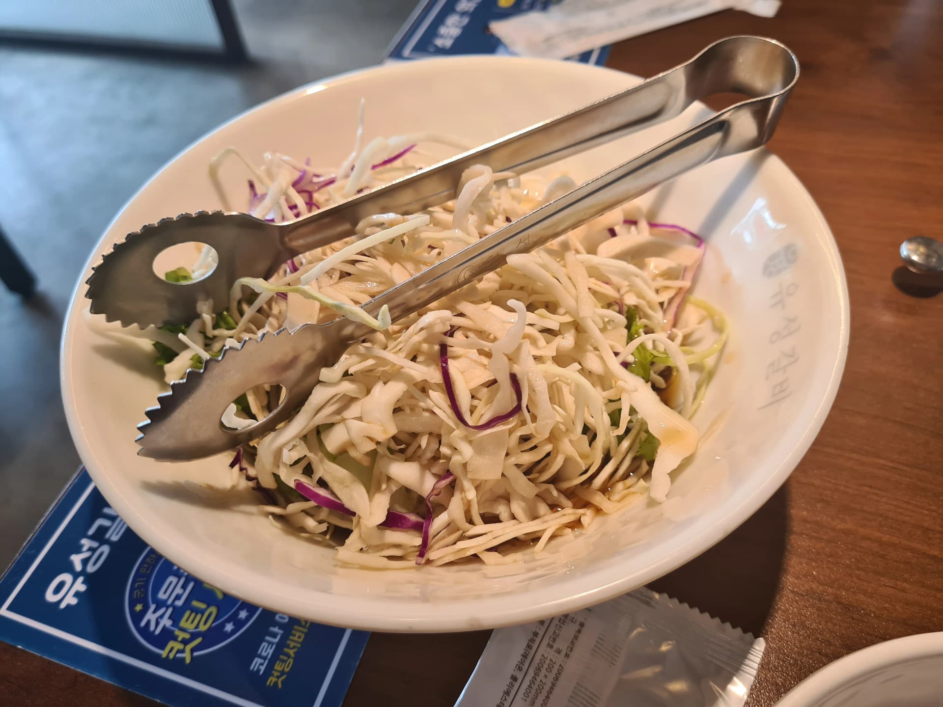 ملفوف أبيض وأحمر مبشور كطبق جانبي مع مشويات على الفحم في مطعم كوري