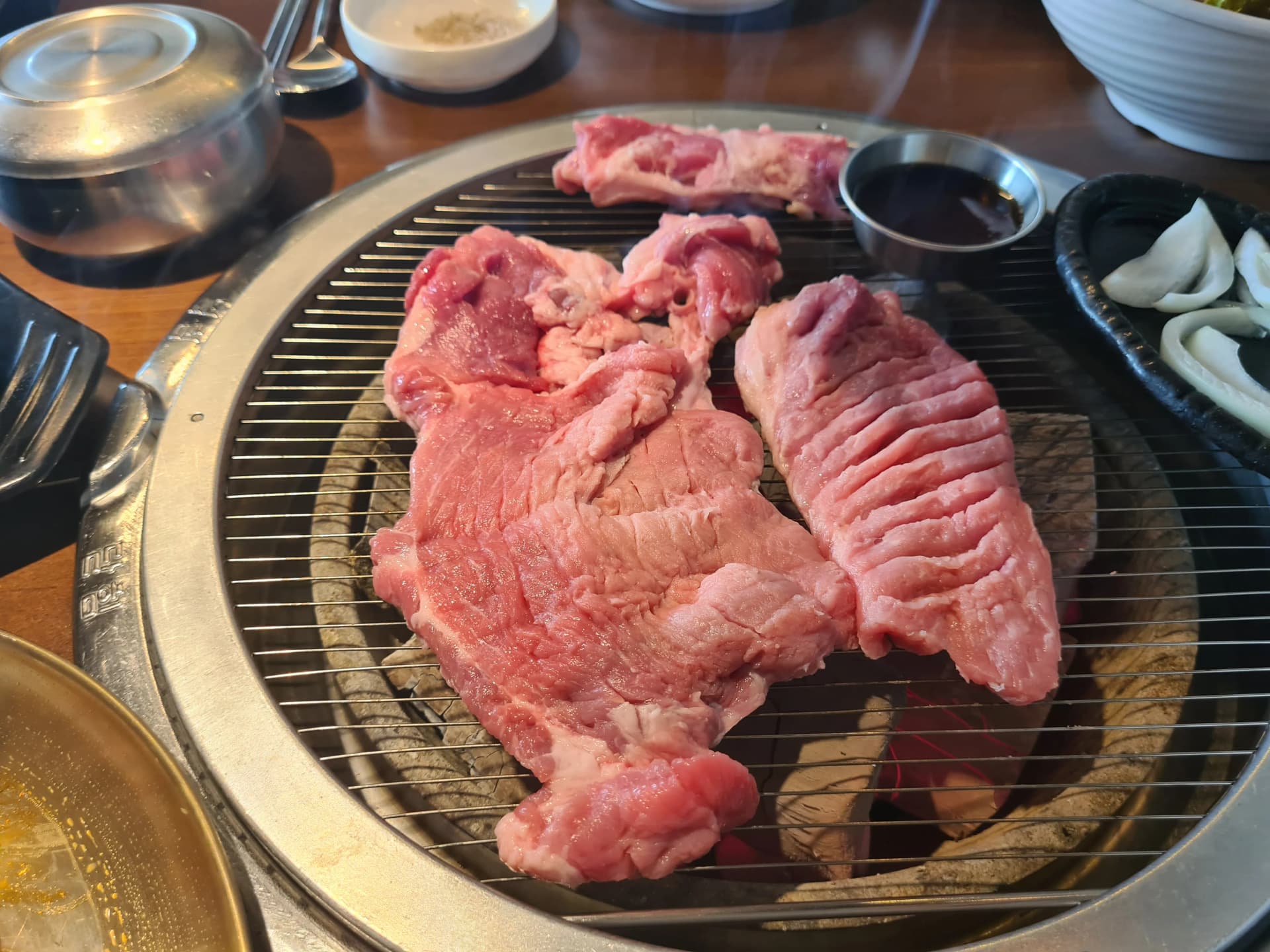 ريش لحم طبيعية طازجة على شبكة فحم بلوط متوهج في مطعم شواء كوري