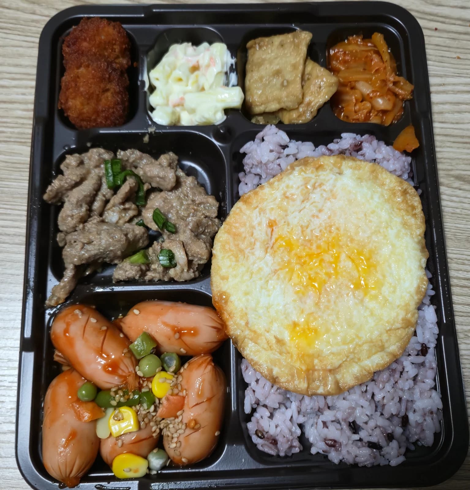 Bento Hyejaroun completo con riso nero uovo bulgogi salsicce kimchi e insalata
