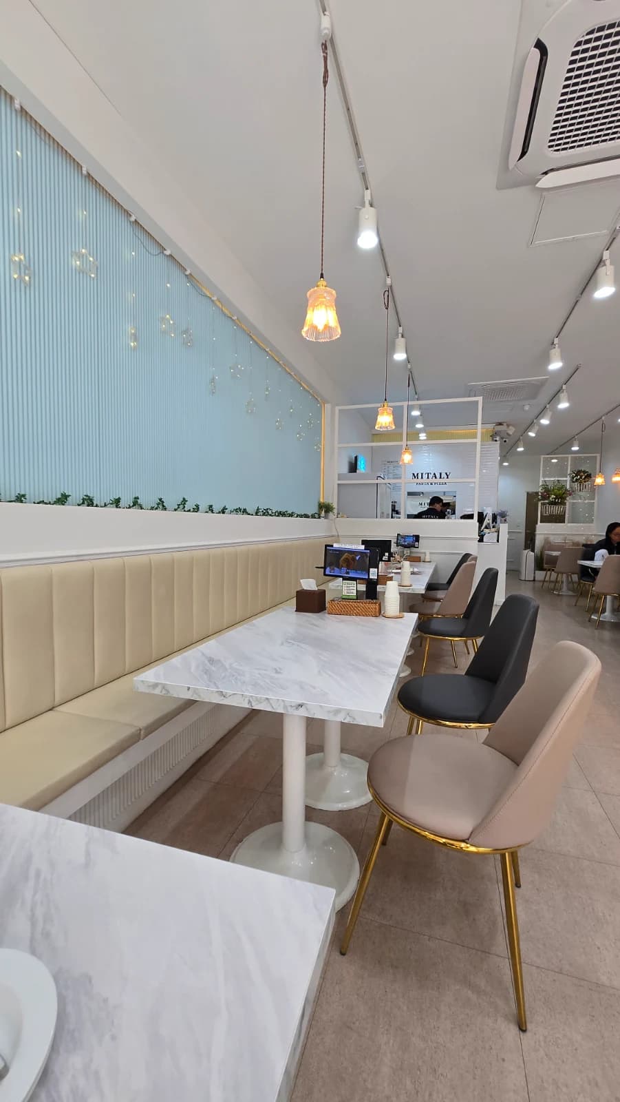 Inside Mitaly Yeongam Samho branch with sky-blue walls and marble tables