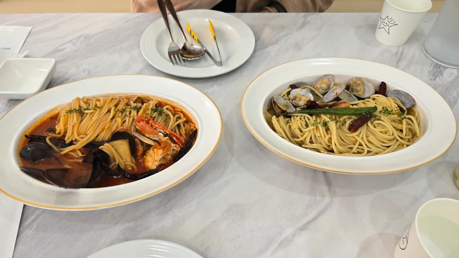 Mitaly seafood jjamppong pasta and vongole pasta side by side on the table