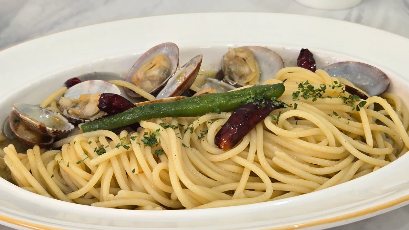 Close-up of Mitaly vongole pasta showing dried chili pepper and shishito pepper