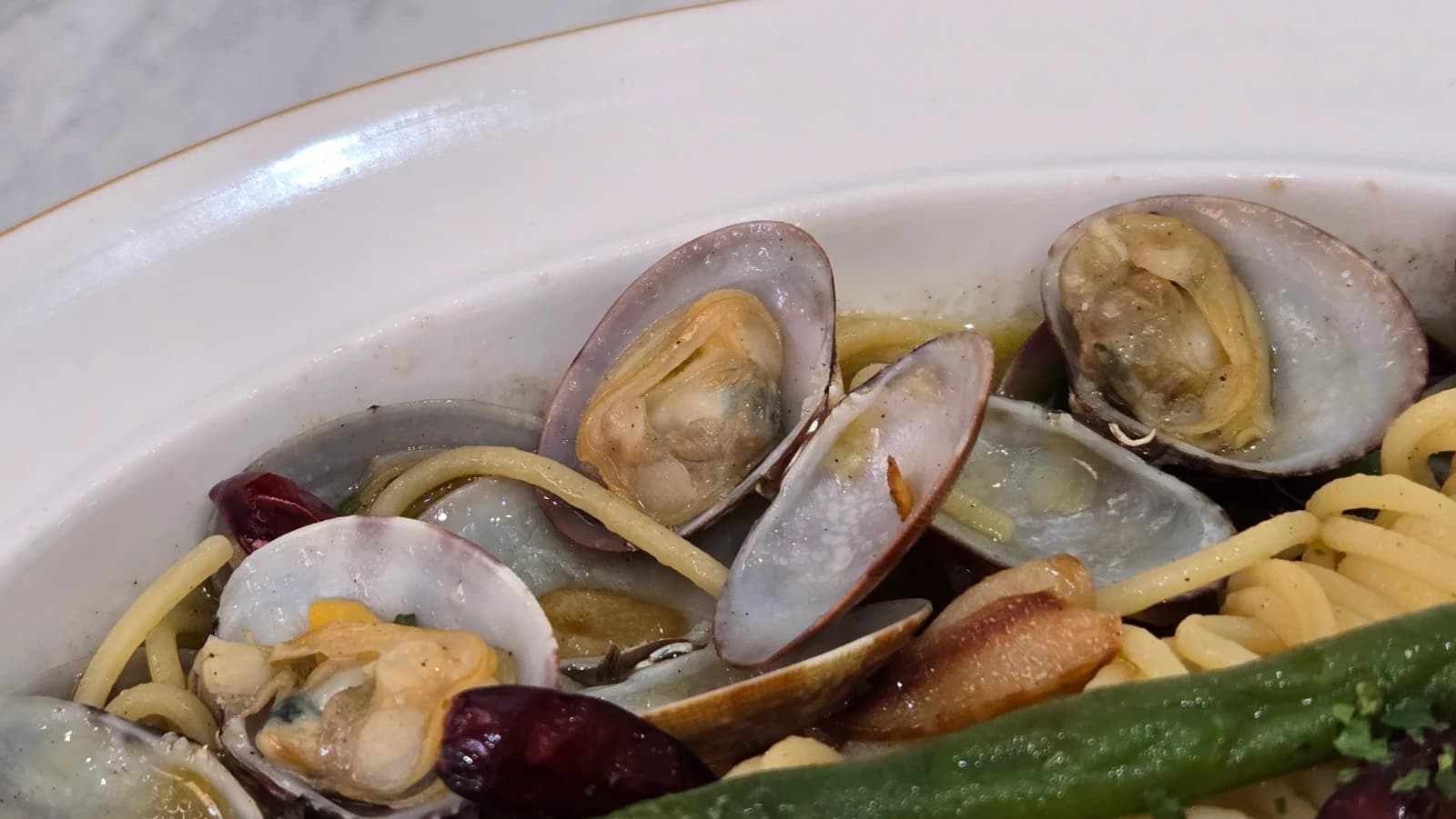 Close-up of vongole spaghetti noodles glistening with olive oil