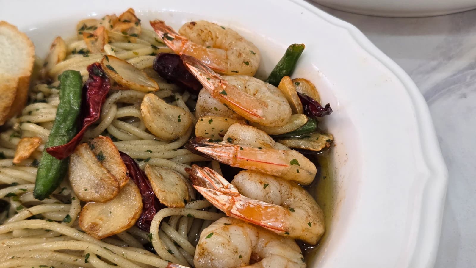 Close-up of gambas pasta shrimp with crispy garlic chips nestled in the noodles