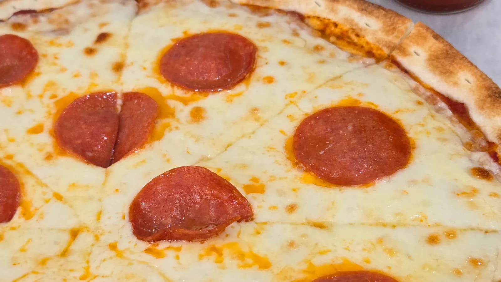 Lifting a slice of Mitaly pepperoni pizza with cheese stretching from the pie