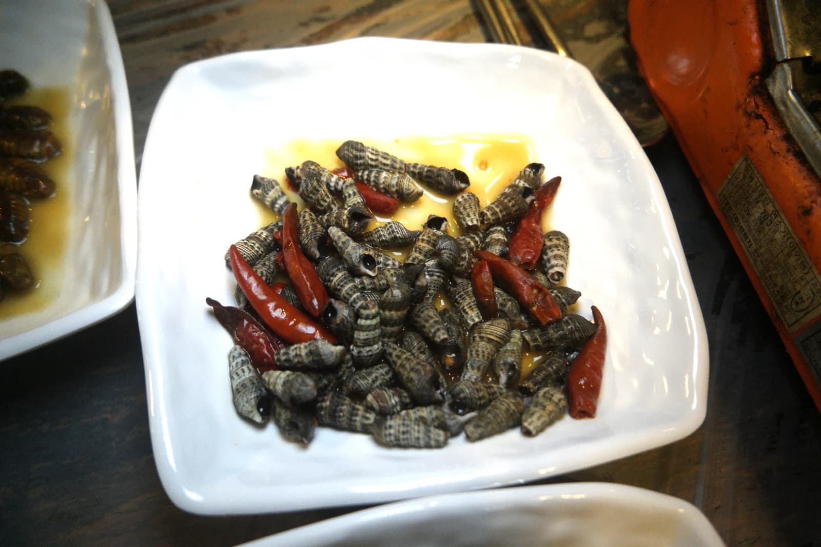 Braised marsh snails with dried chili peppers served as a side dish