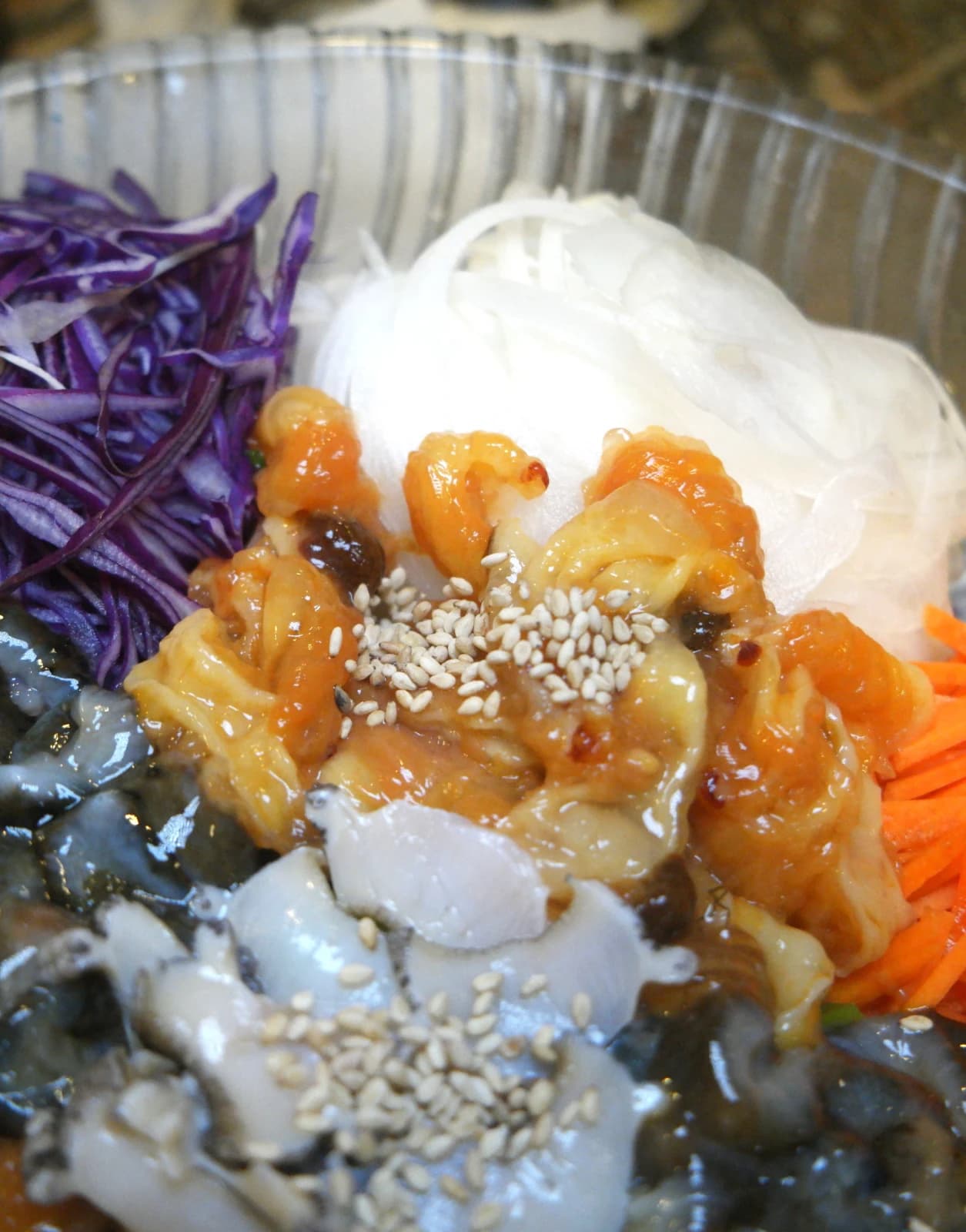 Close-up of sea squirt and sea cucumber in mulhoe topped with sesame seeds