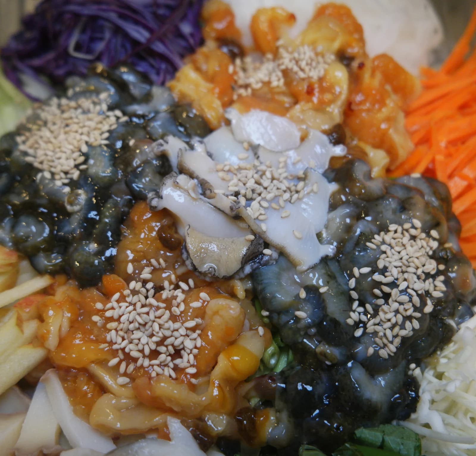 Sea squirt and sea cucumber tossed in red pepper sauce at the center of mulhoe bowl