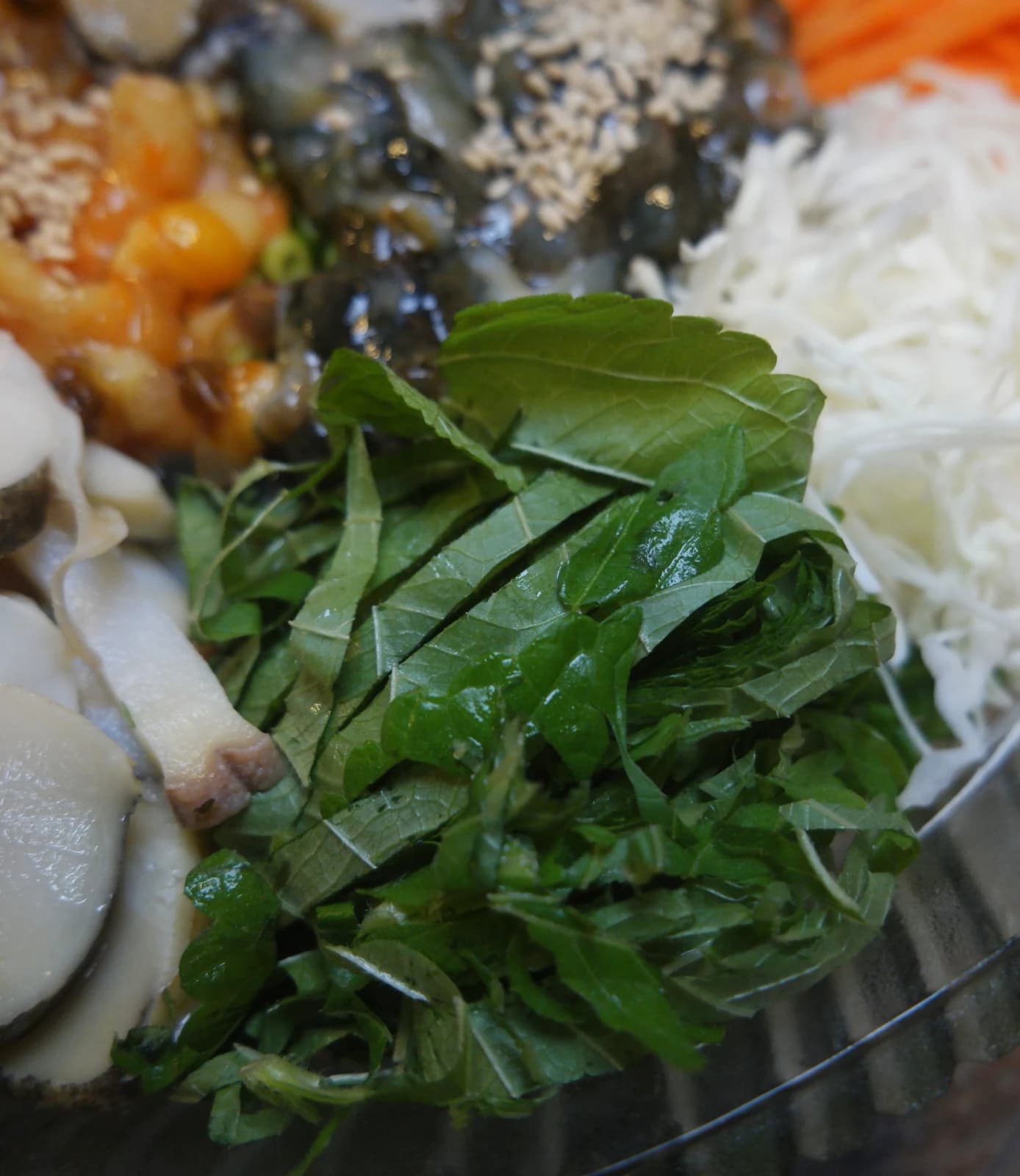 Close-up of julienned perilla leaves piled in a mulhoe bowl