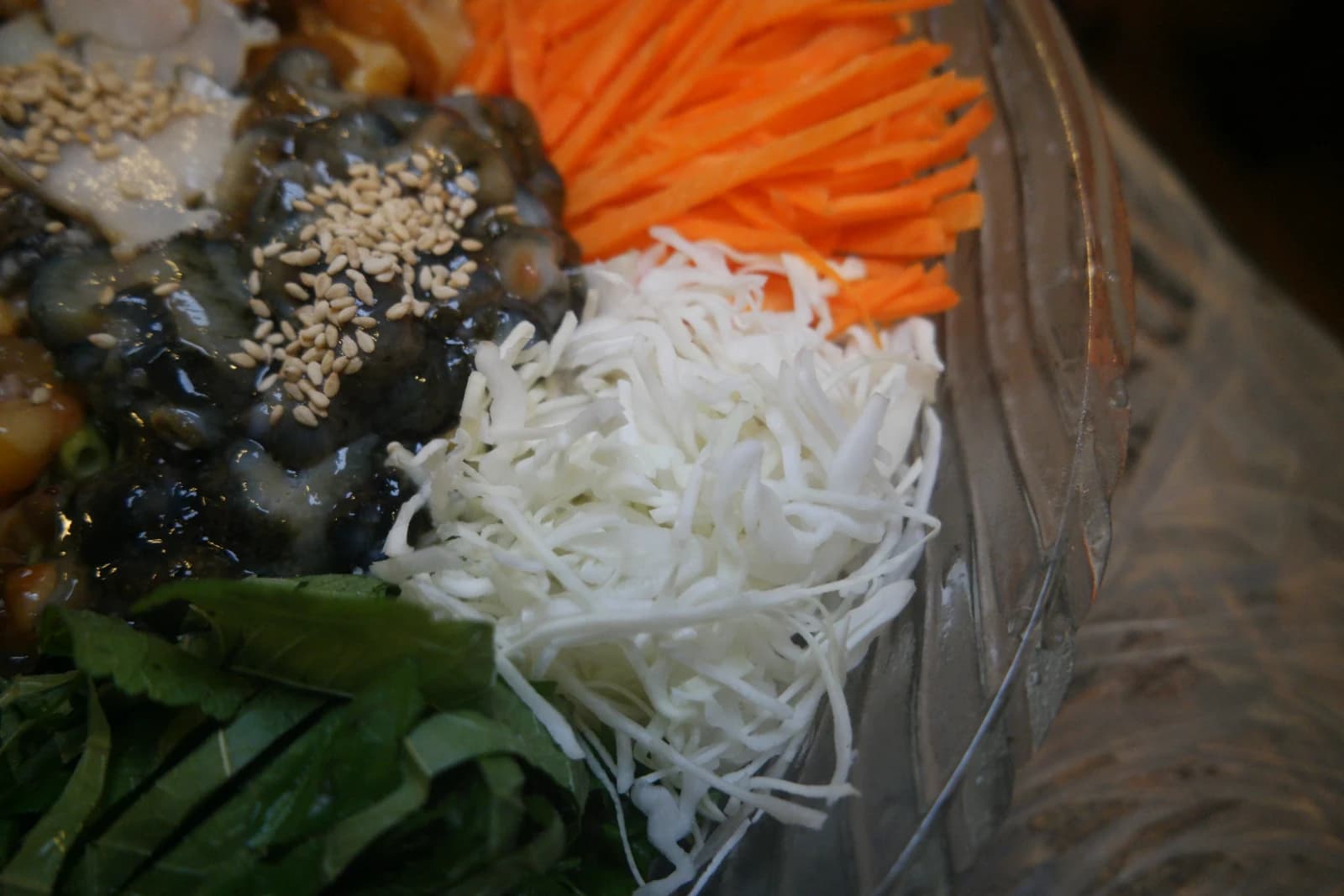 Julienned cabbage and carrot strips arranged in a mulhoe bowl