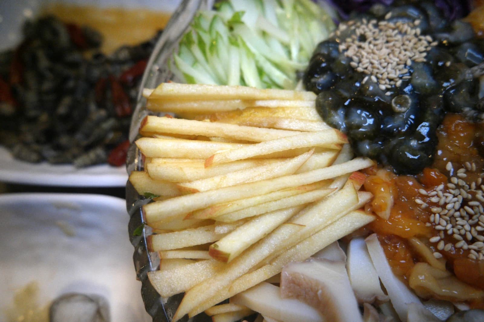 Matchstick-cut apple and cucumber slices in a spicy mulhoe seafood bowl
