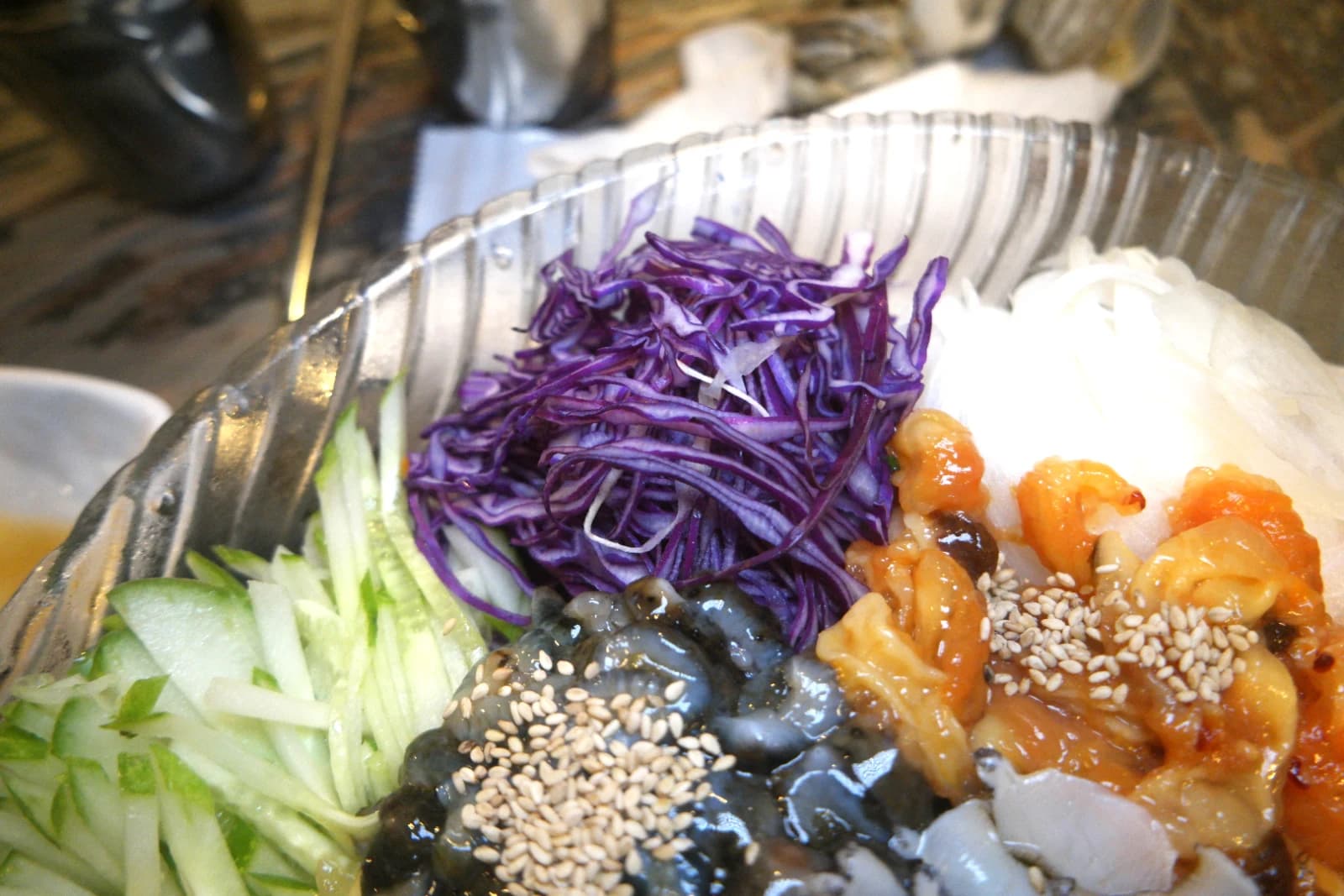 Julienned red cabbage and white onion in a mulhoe seafood bowl