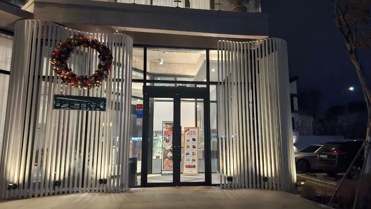 Ƙofar shigar PETRA cafe - farin katako da fitilun ƙasa, ƙirar zamani mai kama da resort | 하이제이에스비