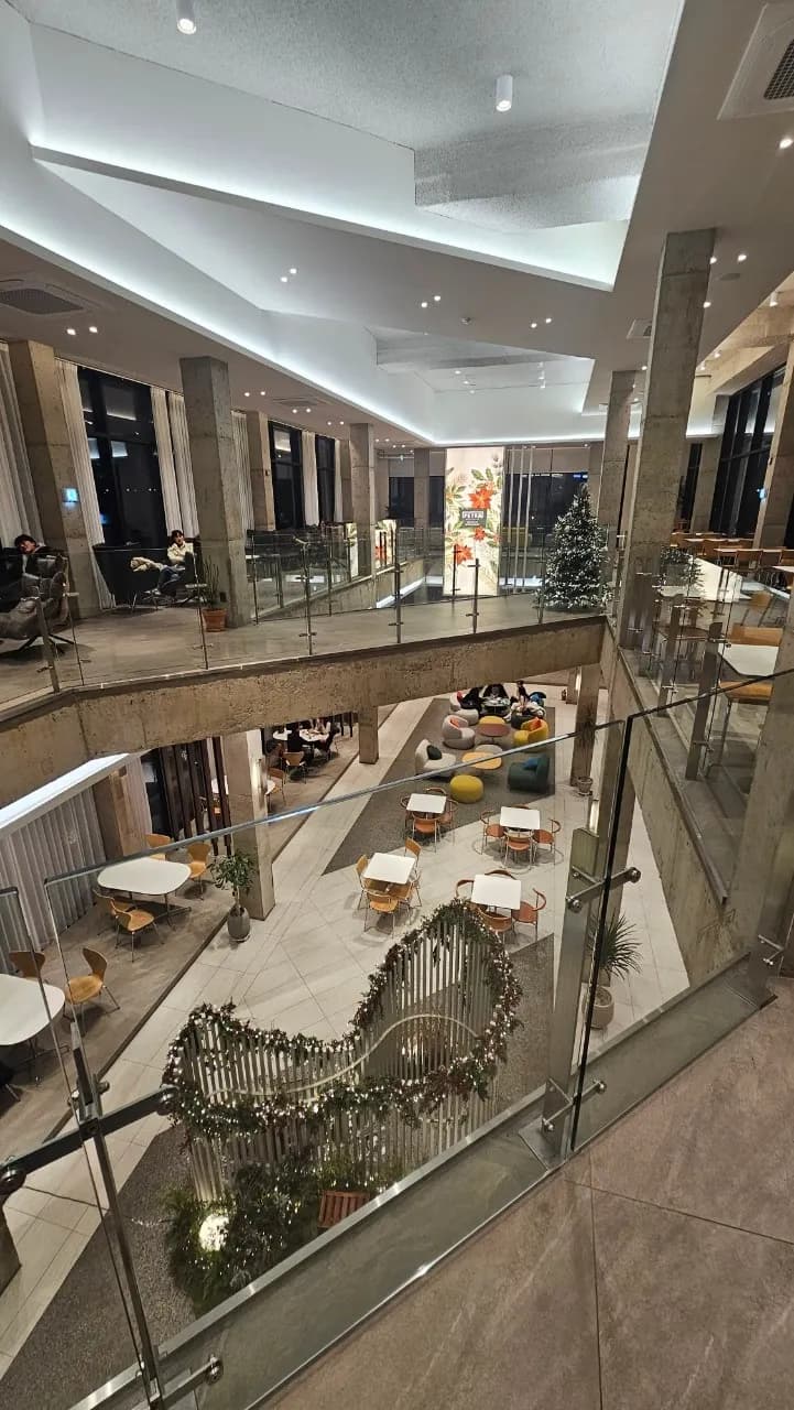 Kallon PETRA cafe daga bene na biyu - babban kofi gida mai rufin sama da yawa, siminti da fitilu masu faɗi | 하이제이에스비