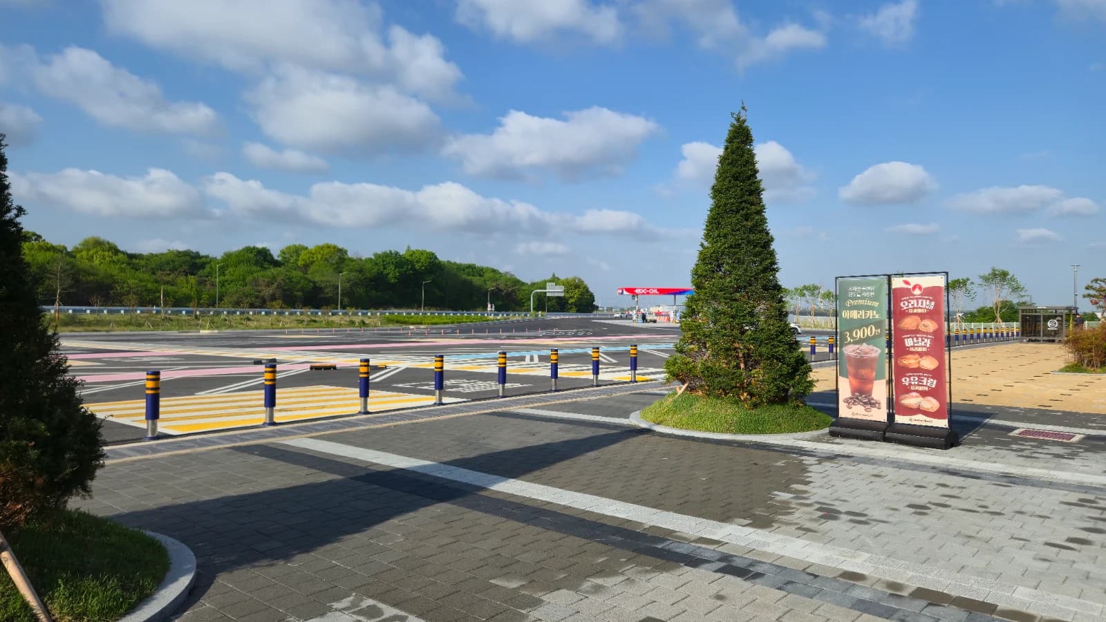 Gimje rest stop parking lot overview with advertising banner and gas station roof behind