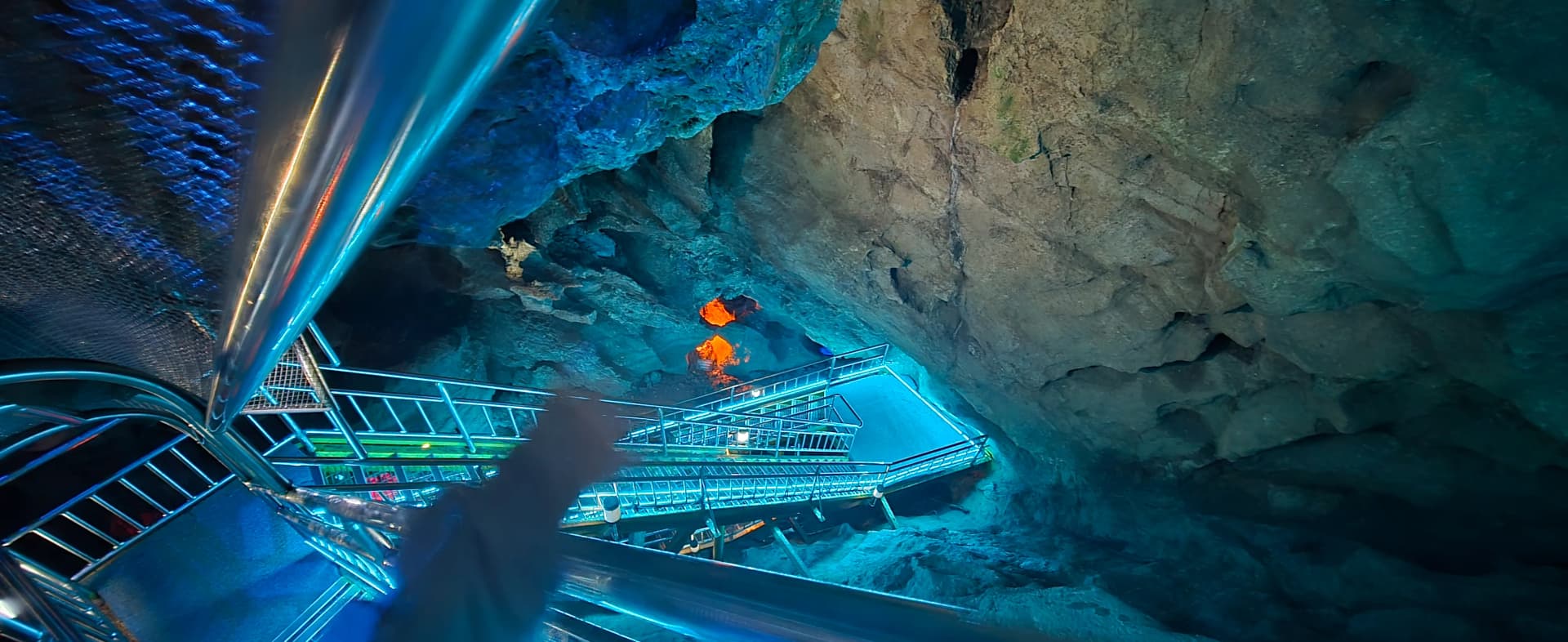 Pandangan dari bawah ke atas tangga dan pagar besi berlapis-lapis di Gua Hwaam | 하이제이에스비