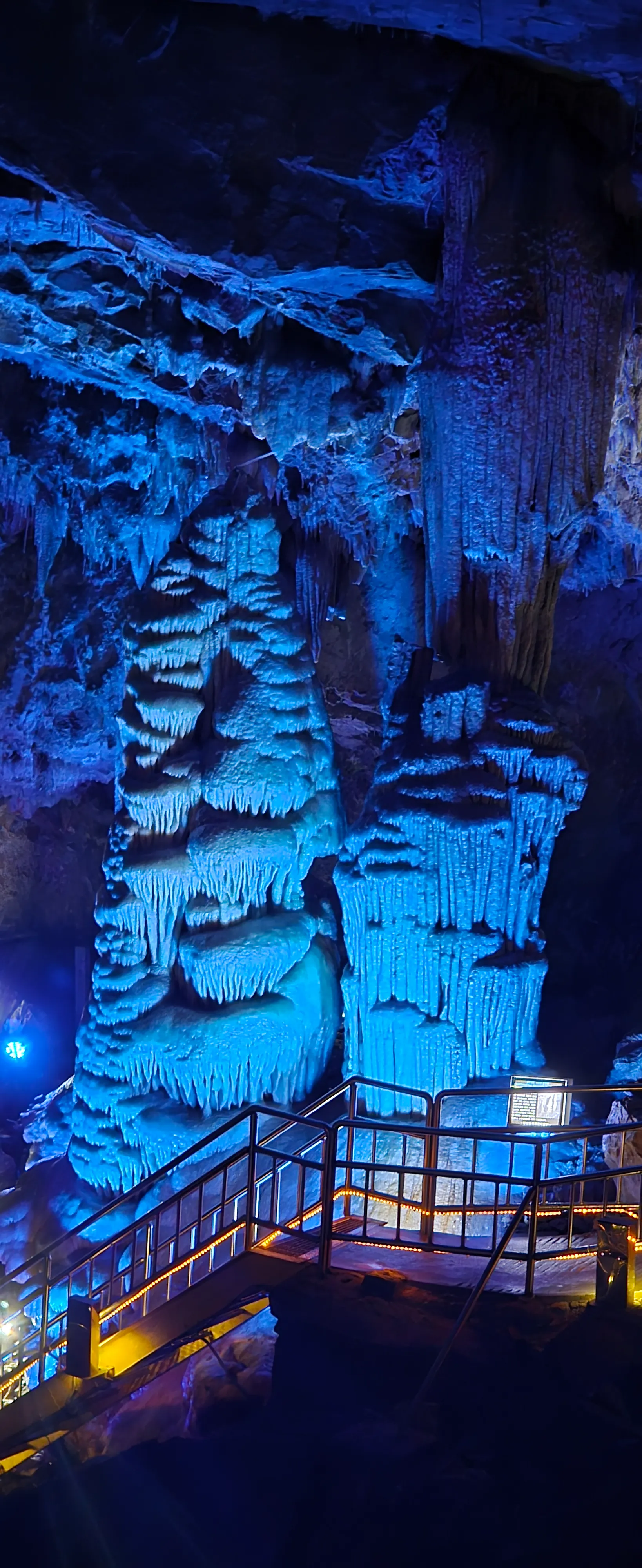 Tiang batu gergasi berlilit 5 meter dan tinggi 8 meter dilihat dari hadapan di bawah cahaya biru | 하이제이에스비