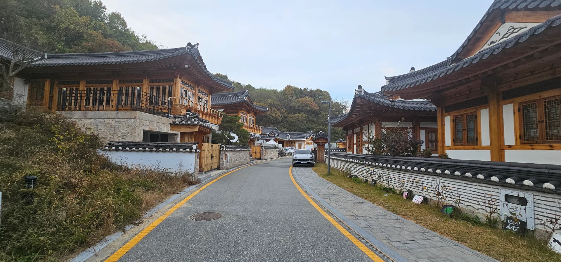 고운동 한옥마을 전경 — 여러 채의 한옥이 석축을 따라 나란히 늘어서 있다 | 하이제이에스비