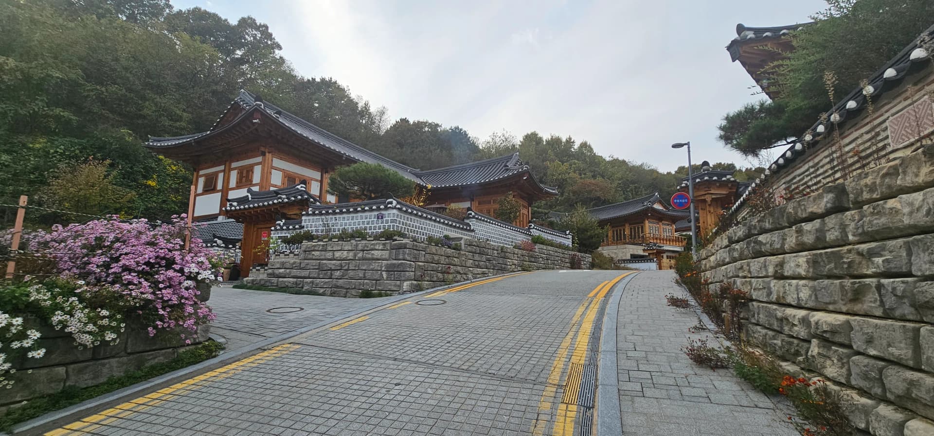 한옥 대문에 한자로 집 이름이 걸려 있고, 대문 앞에 차량이 주차되어 있다 | 하이제이에스비