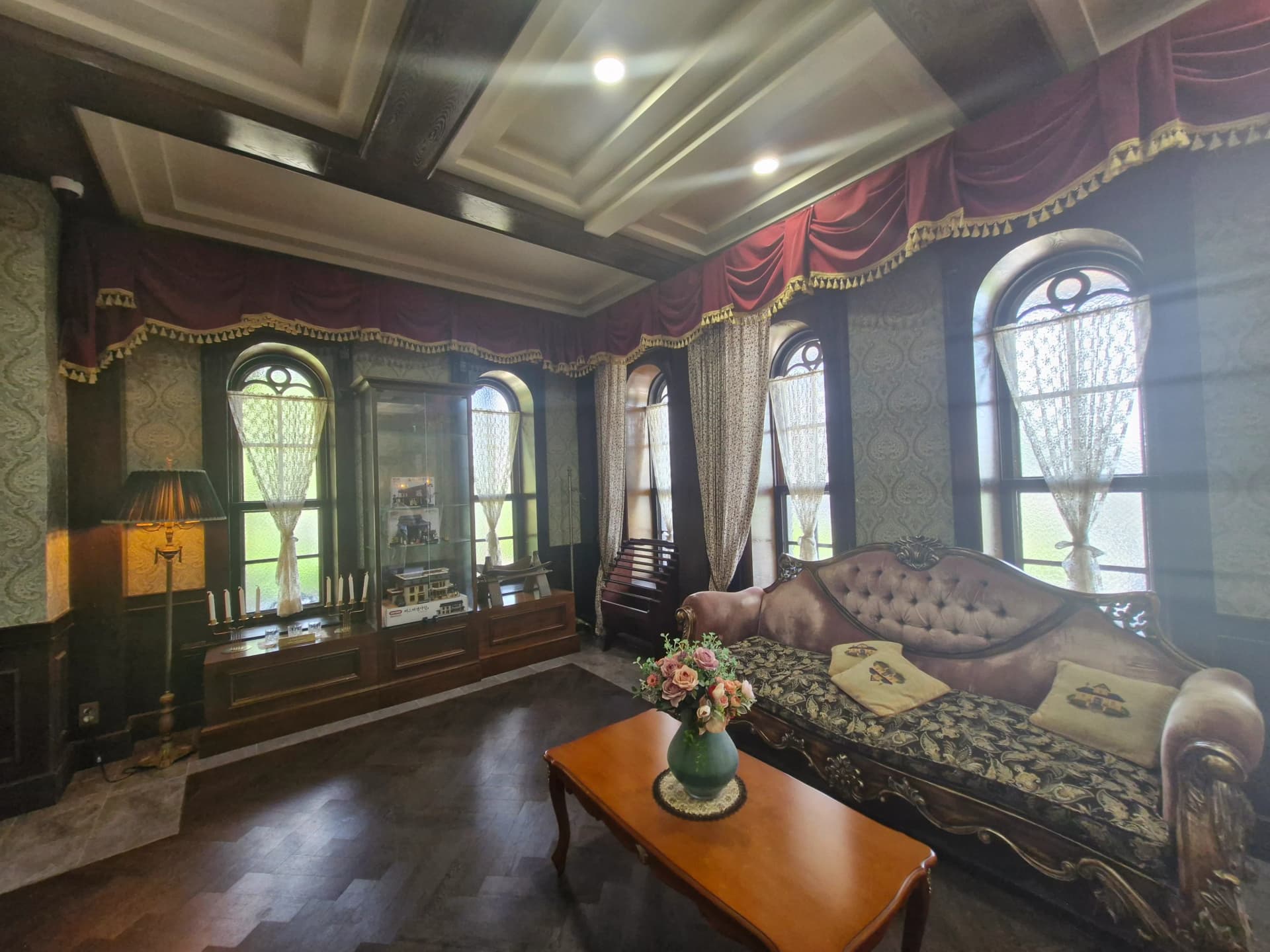 Interior lantai 1 Glory Hotel dengan panel kayu gelap dan tirai beludru | 하이제이에스비