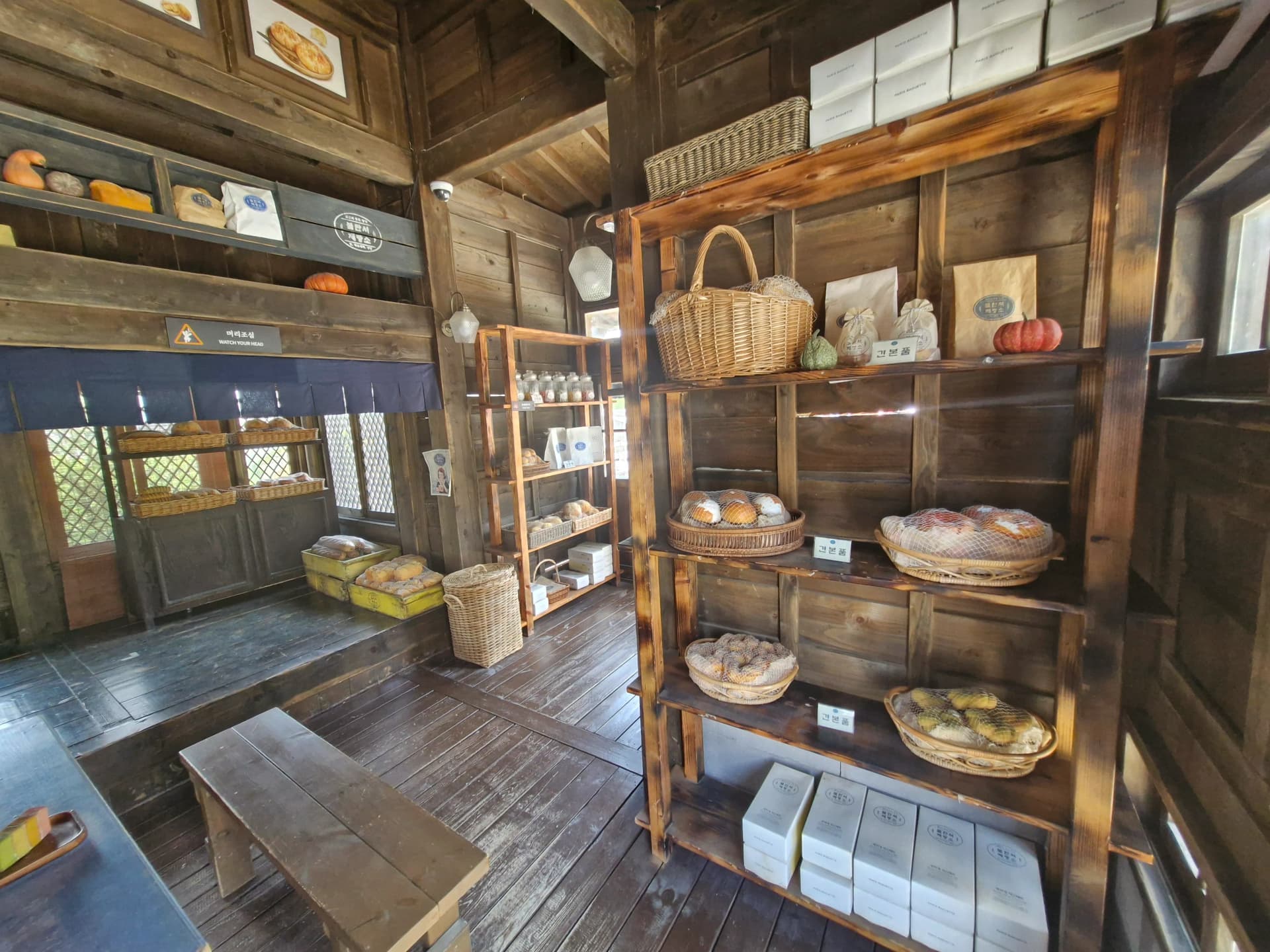 Eksterior Toko Roti Bullangseo dengan keranjang roti di rak kayu | 하이제이에스비
