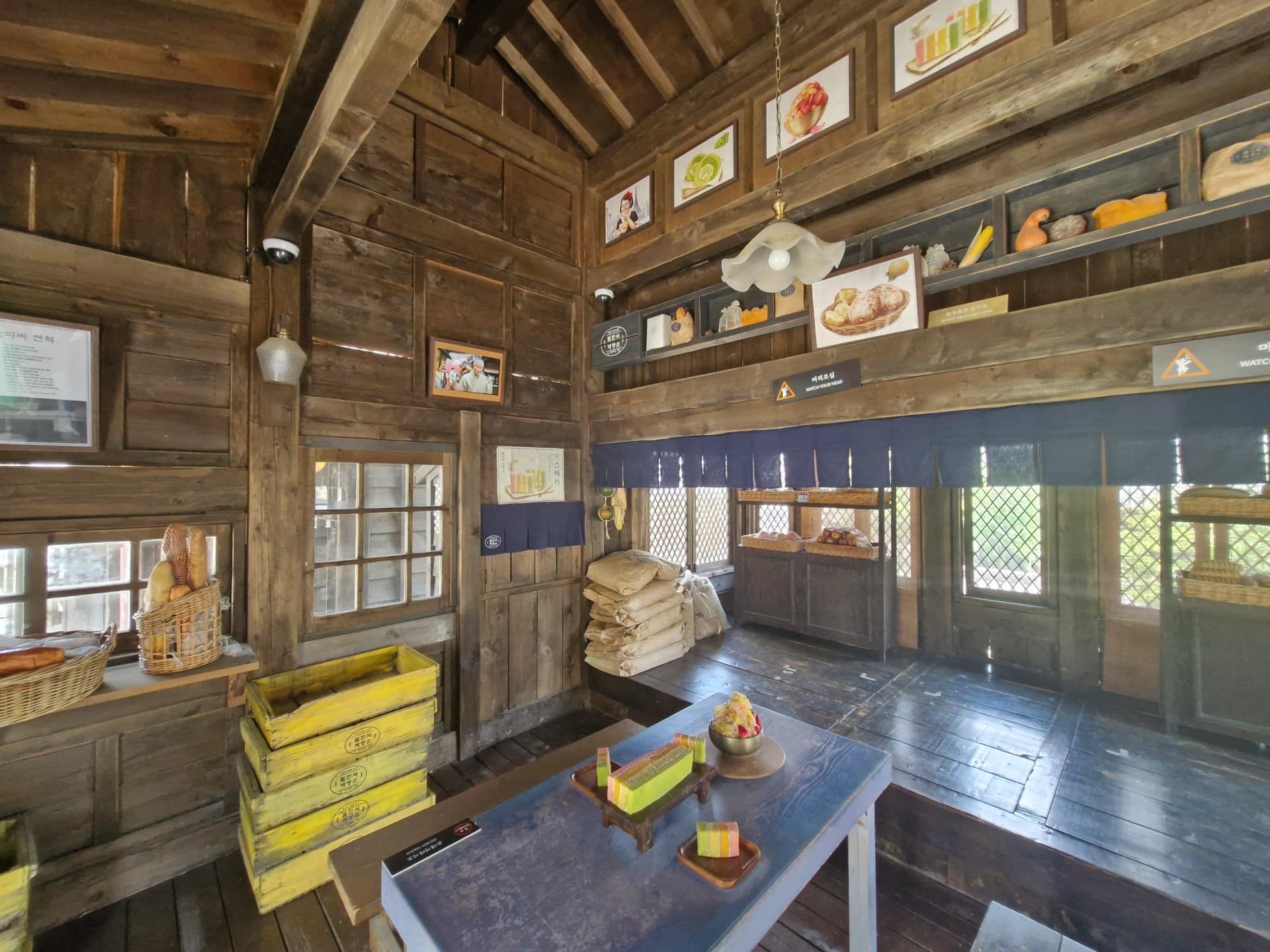 Interior Toko Roti Bullangseo dengan struktur kayu ekspos dan foto syuting drama | 하이제이에스비