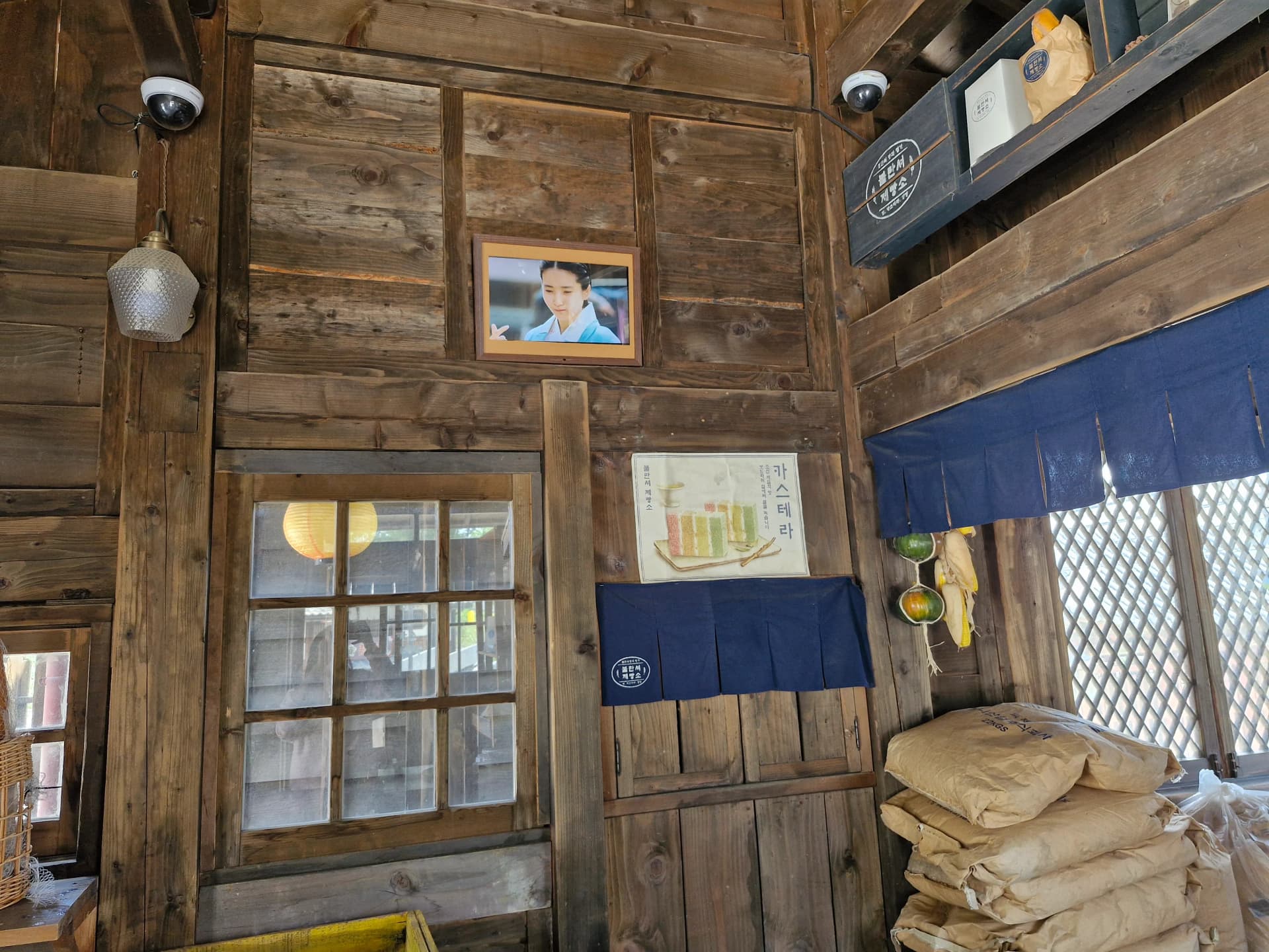 Foto aktor dan poster castella di dinding toko roti | 하이제이에스비