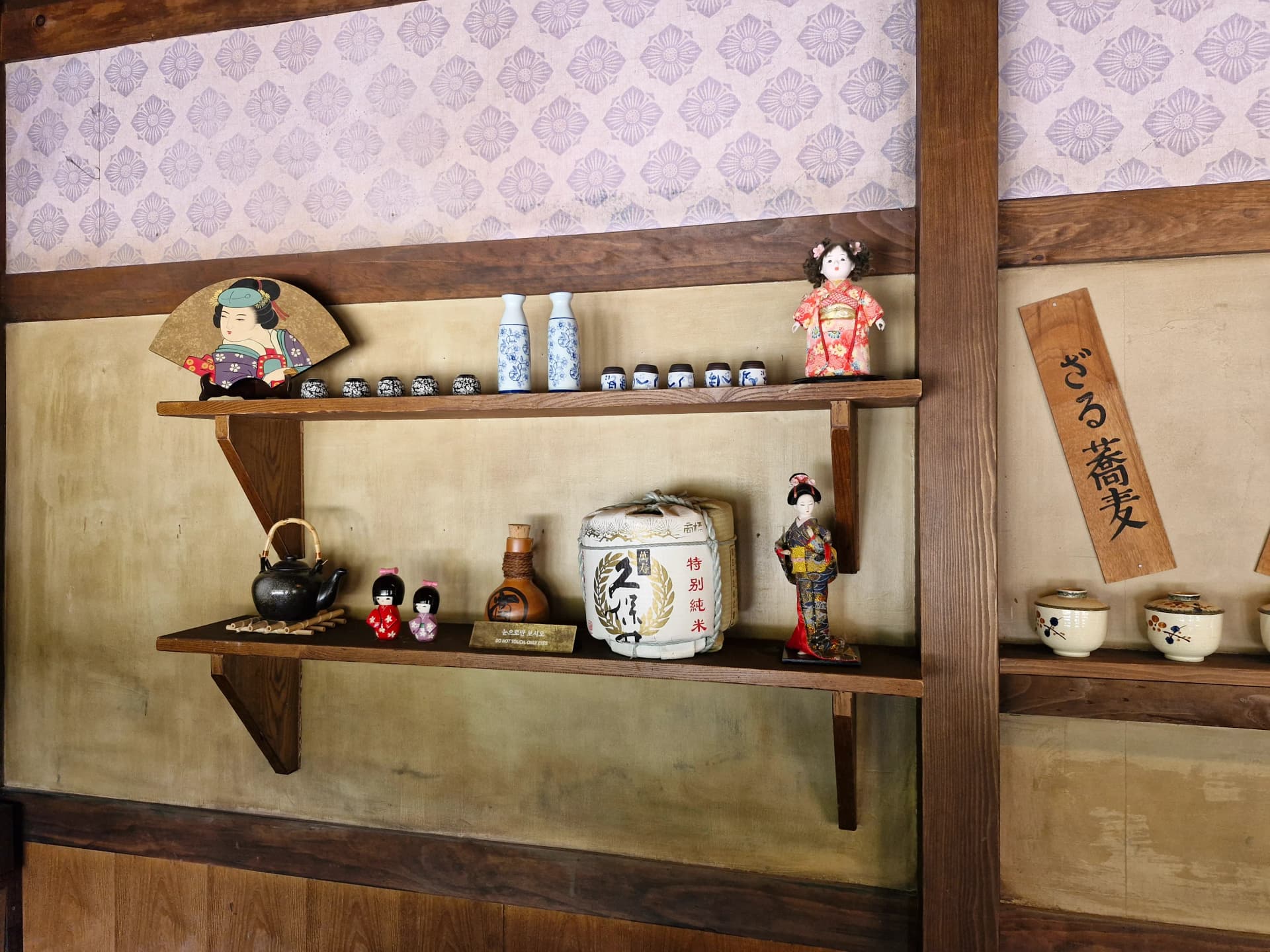 Rak kedai sake Jepang dengan boneka kimono, kipas, tong sake, dan teko | 하이제이에스비
