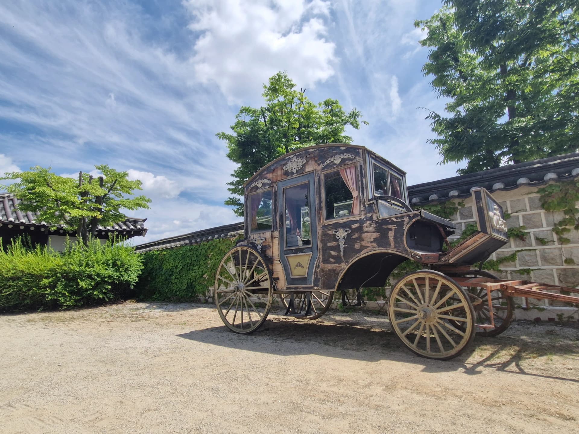 Close-up roda kayu kereta kuda dan ukiran pintu | 하이제이에스비