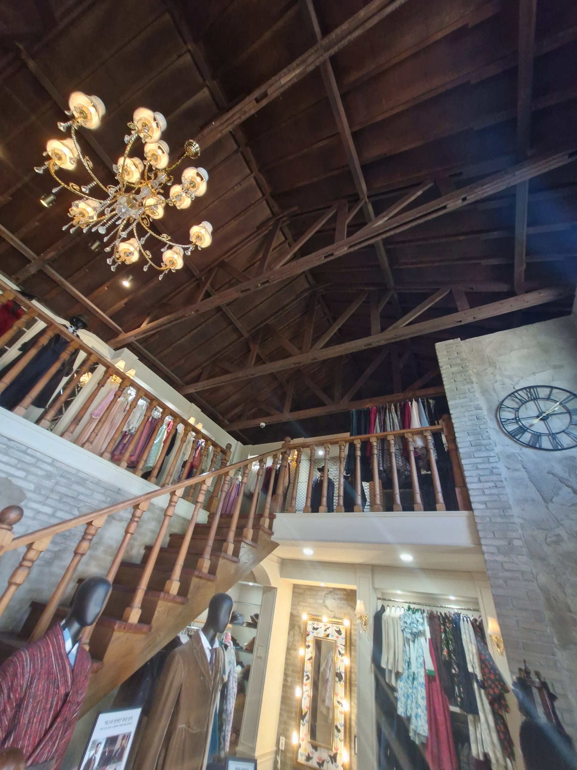 Langit-langit rangka kayu ekspos dengan chandelier di aula sewa kostum | 하이제이에스비