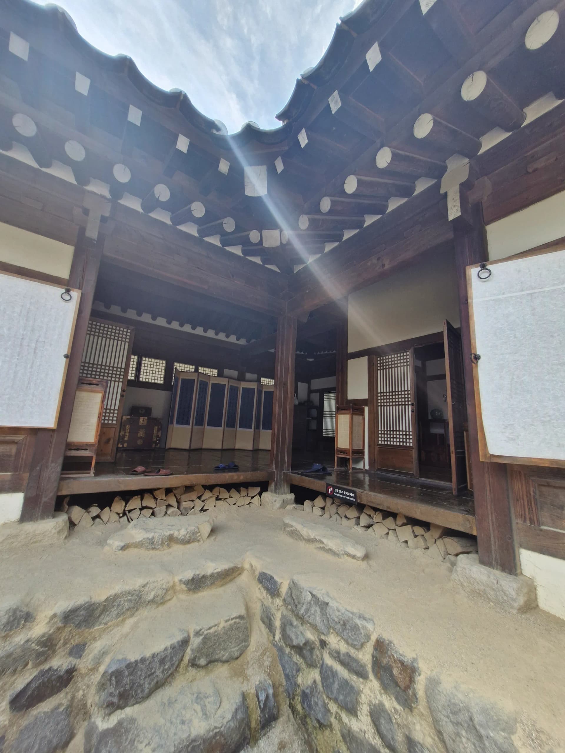 Interior hanok tradisional dengan atap genteng, pintu kertas geser, dan kayu bakar | 하이제이에스비