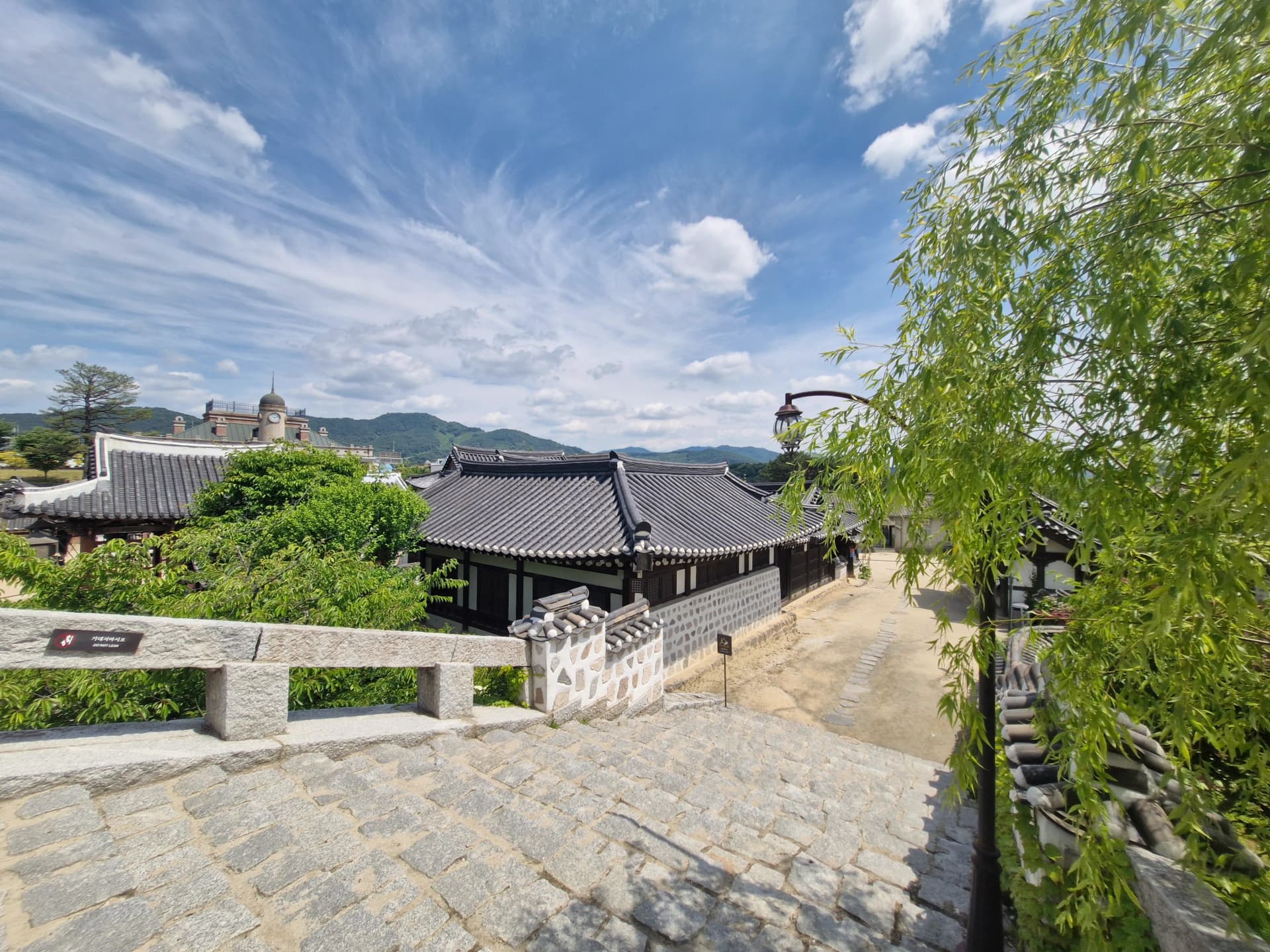 Panorama dari atas jalan hanok dengan kubah menara jam dan pohon willow | 하이제이에스비