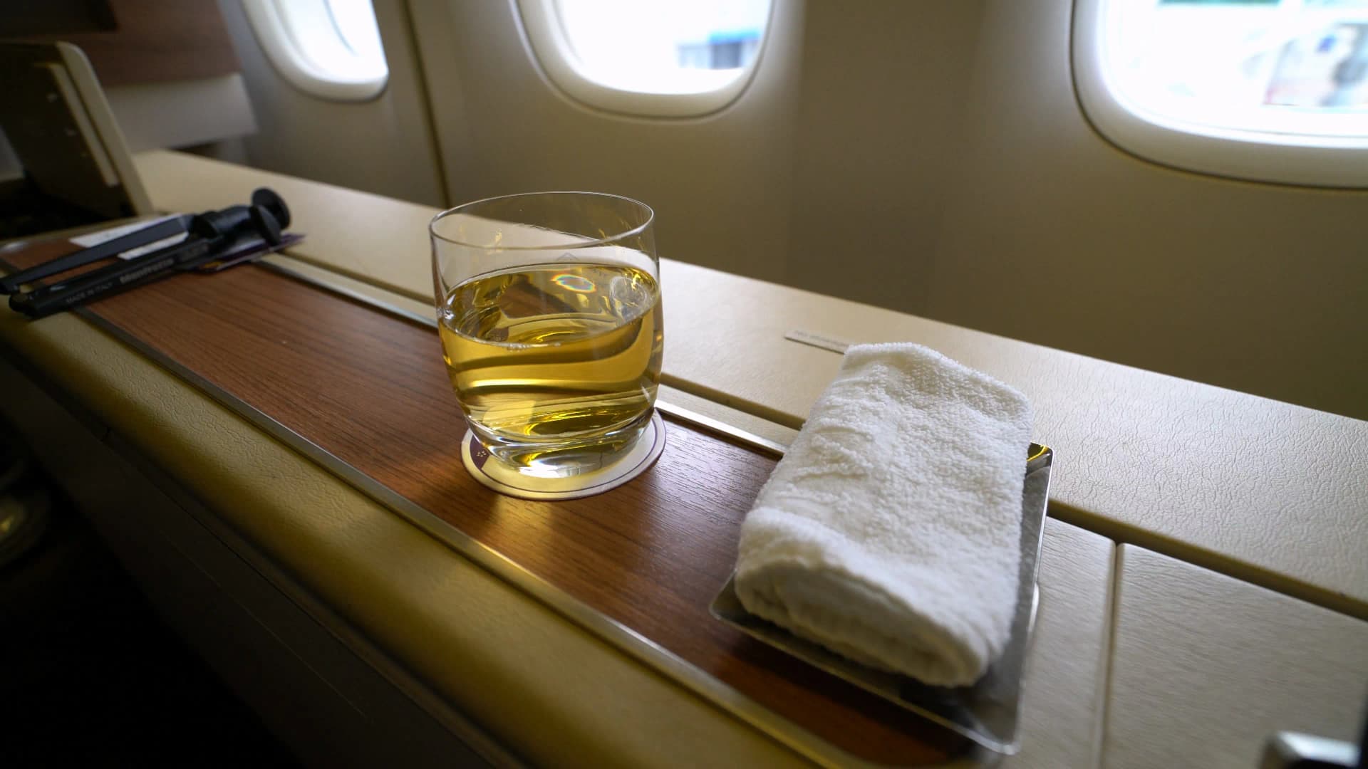 타이항공 로열 퍼스트 클래스 웰컴 드링크 사과주스와 따뜻한 물수건, 우드 톤 콘솔 위 세팅