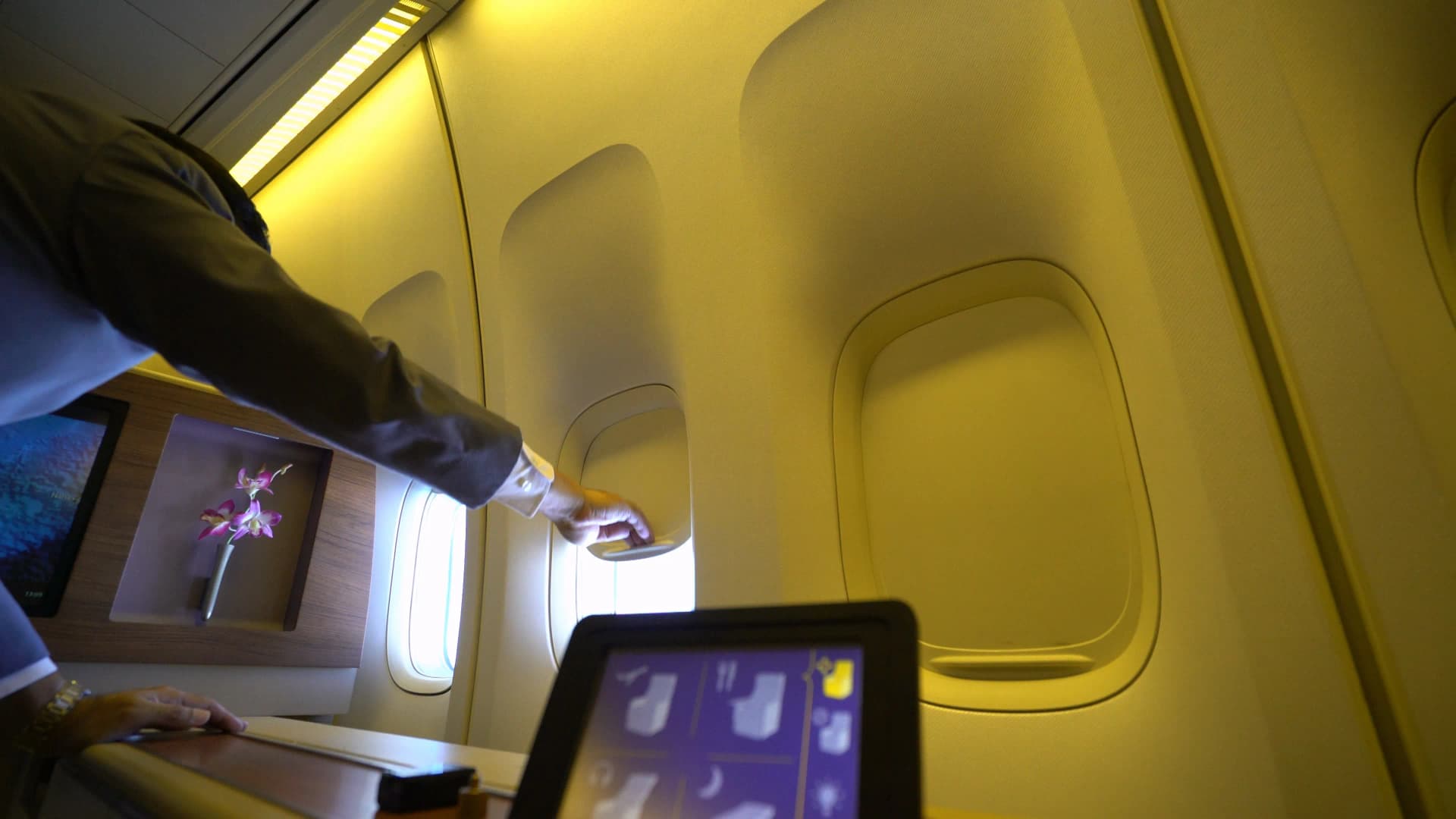 타이항공 퍼스트클래스 승무원이 창문 쉐이드를 하나씩 내려주는 장면, 요청 없이 먼저 서비스