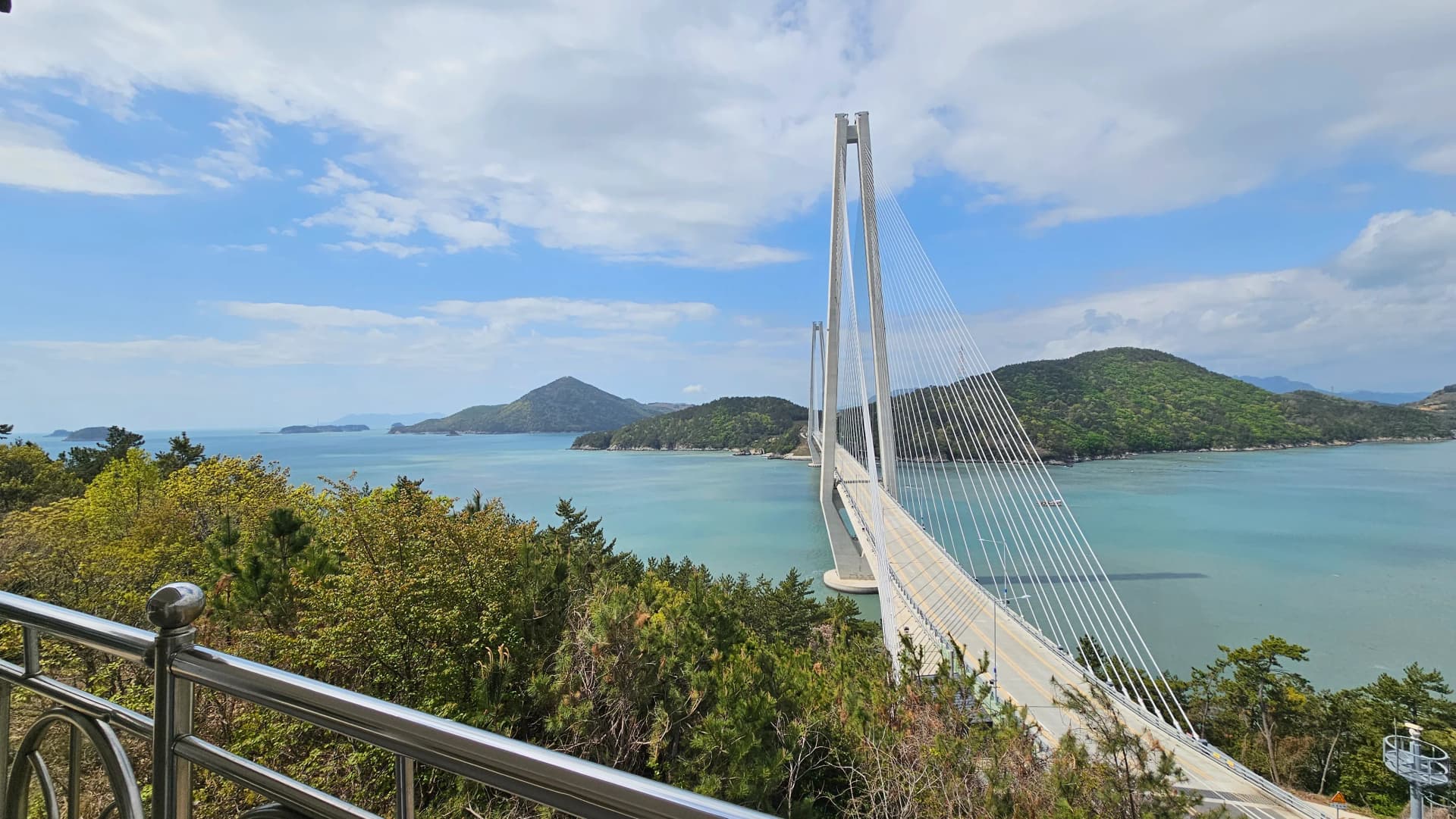 جسر جوبالدي المعلق يمتد فوق البحر بين أشجار الصنوبر مع جزر دادوهيه المتراصة في الأفق